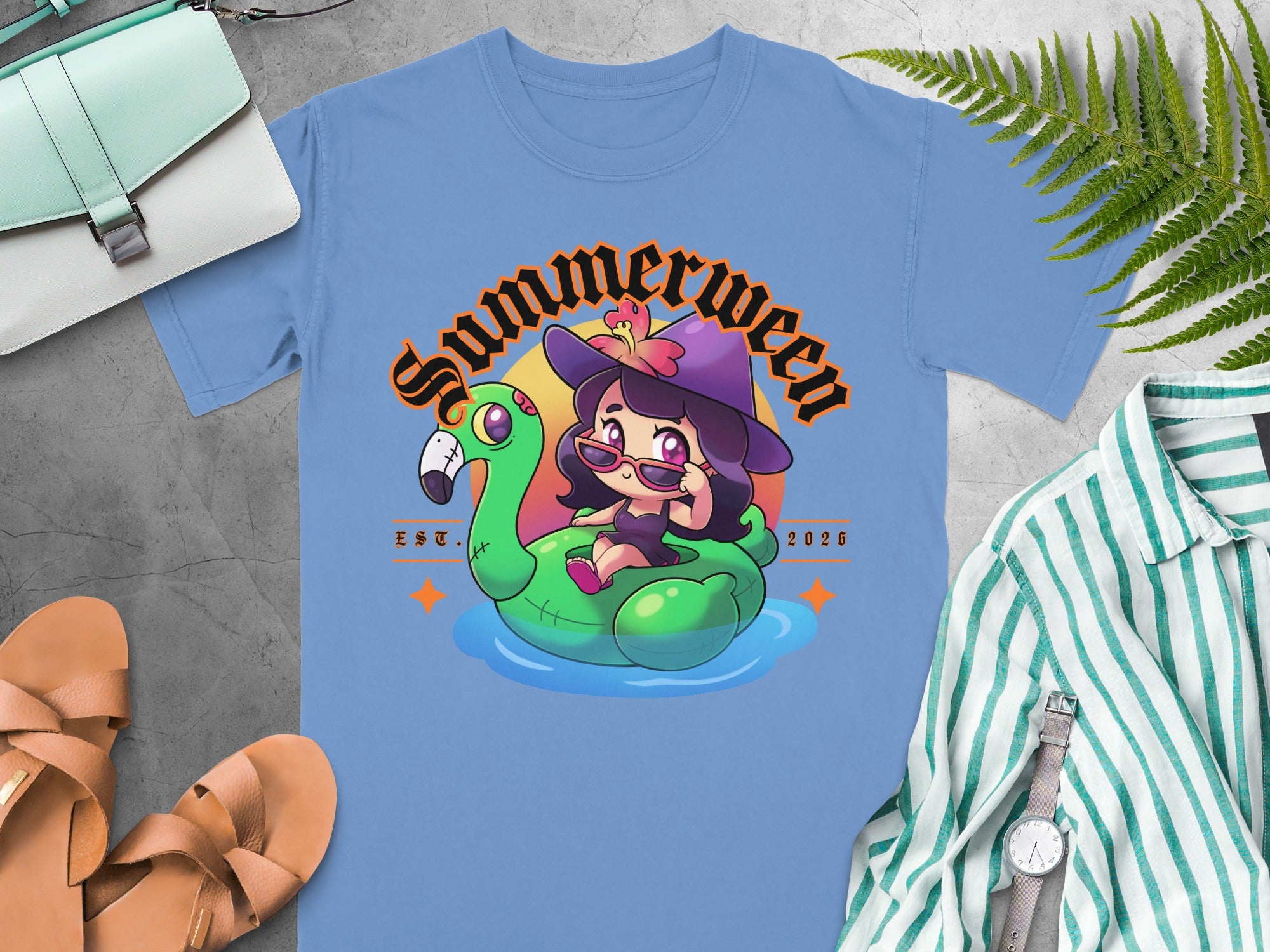 Blue t-shirt with cartoon of witch on flamingo float, "Summerween EST. 2026".