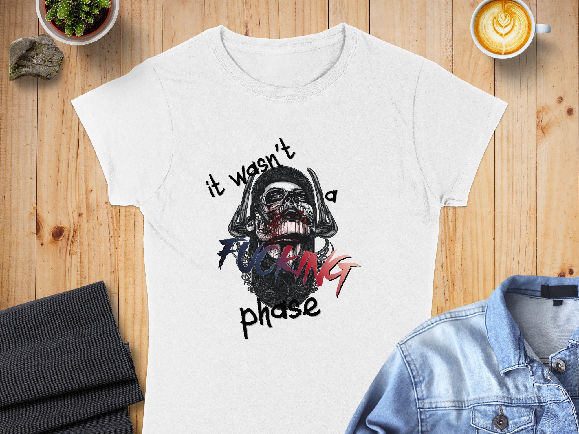White t-shirt with skull graphic and text "it wasn't a fucking phase."
