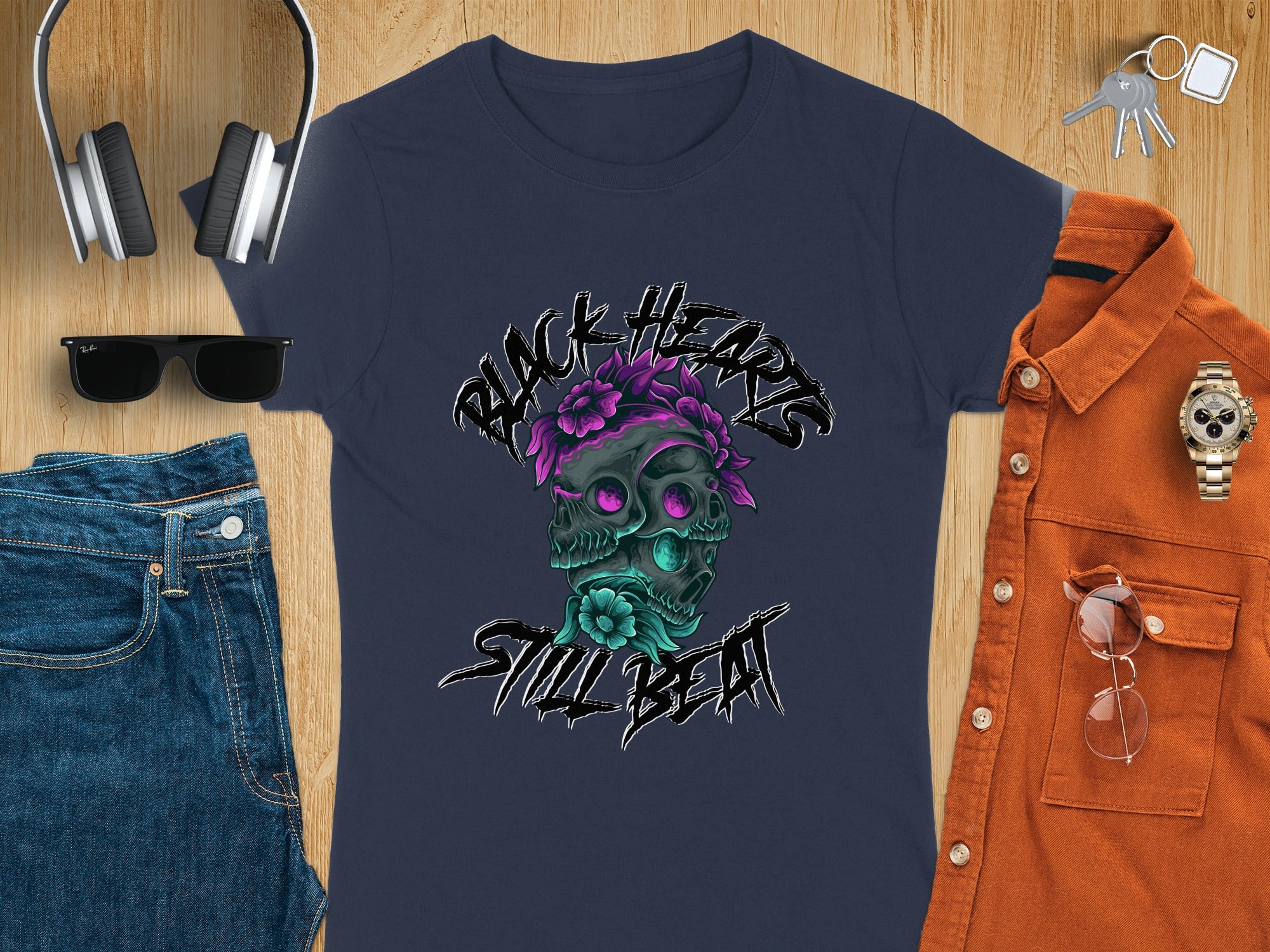 Dark navy t-shirt with "Black Hearts Still Beat" text and twin skull graphic.