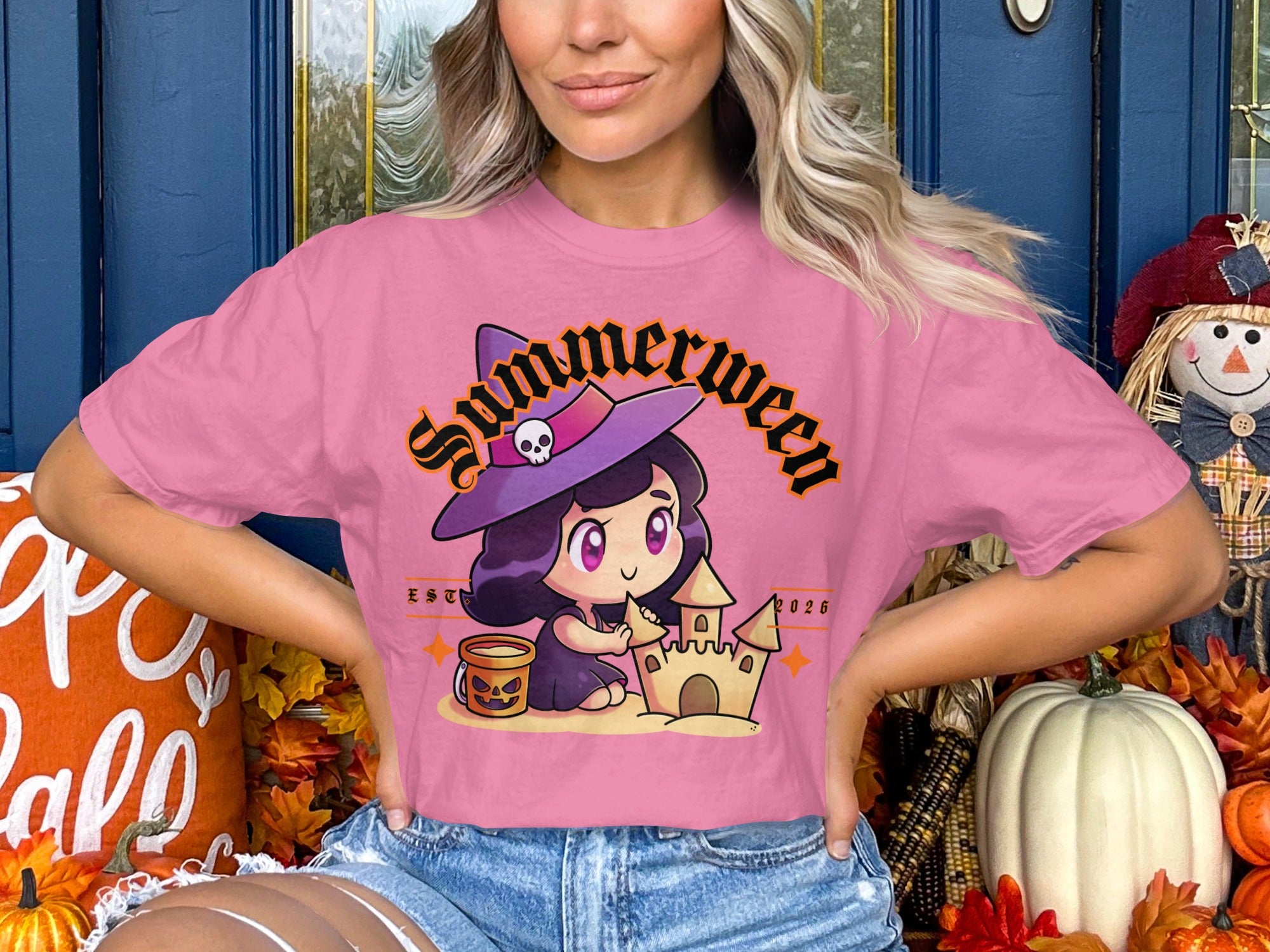 Pink t-shirt with "Summerween" text and a cartoon witch building a sandcastle.