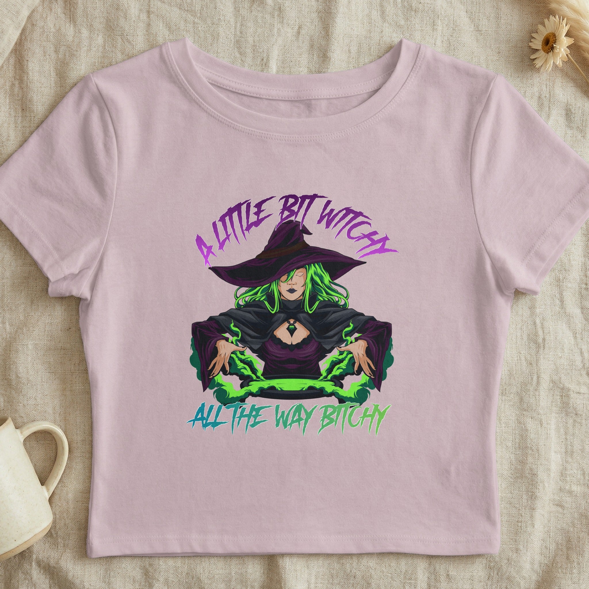 Pink crop top with a witch illustration and text "A little bit witchy all the way bitchy".