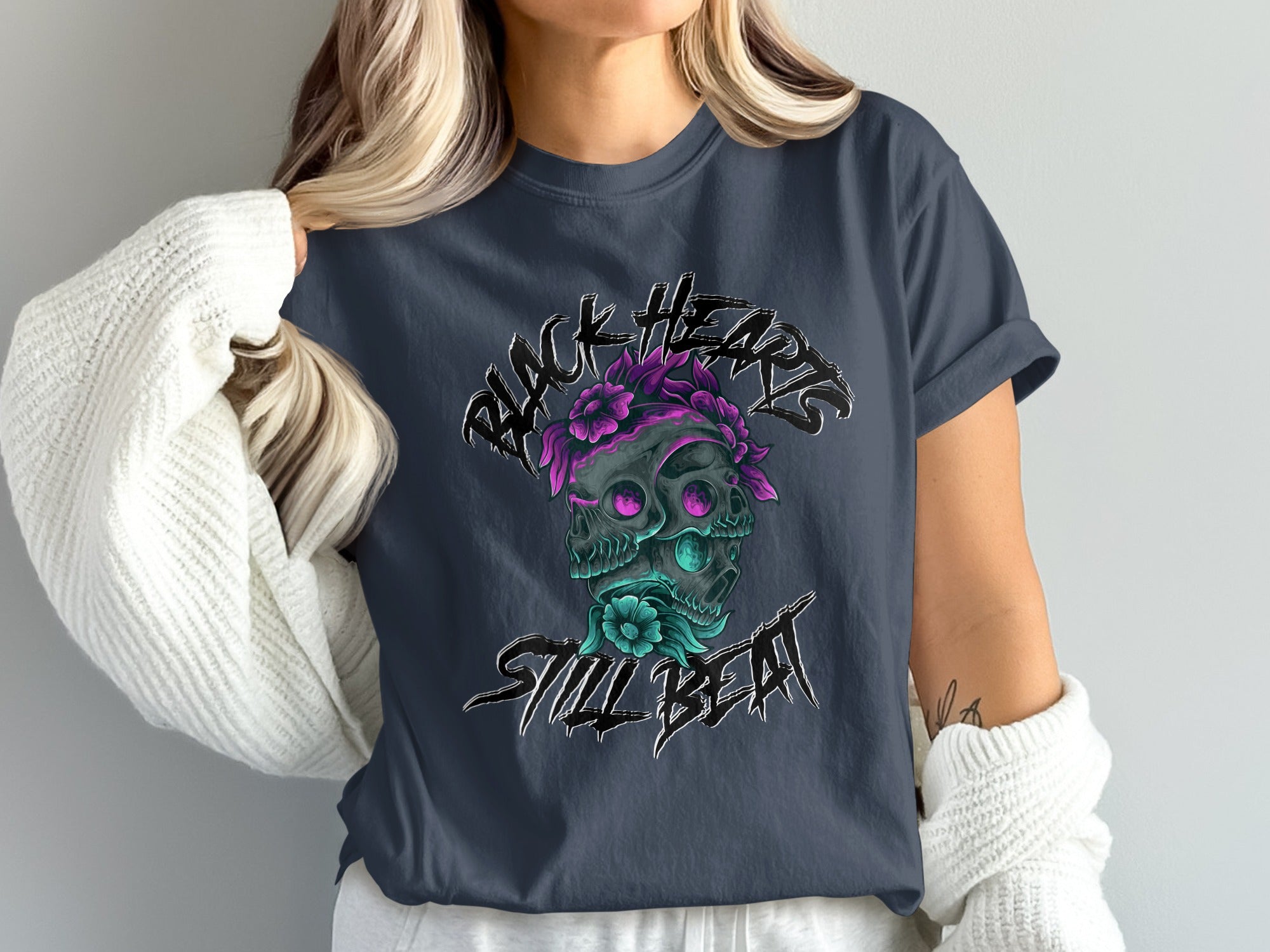 Dark t-shirt with black heart and skull graphic, accented by flowers and text.