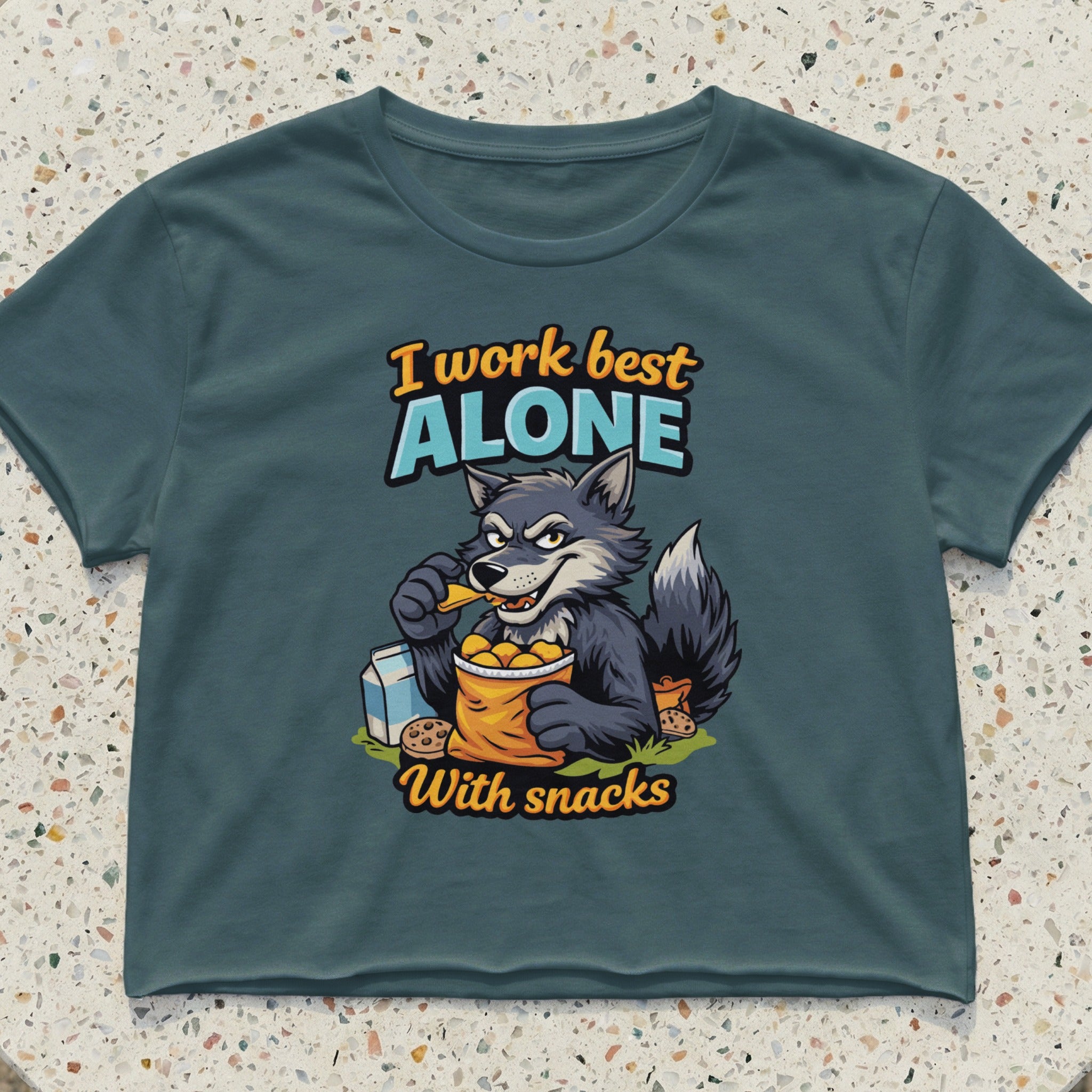 Wolf eating snacks from a bag on a t-shirt with text "I work best alone with snacks".