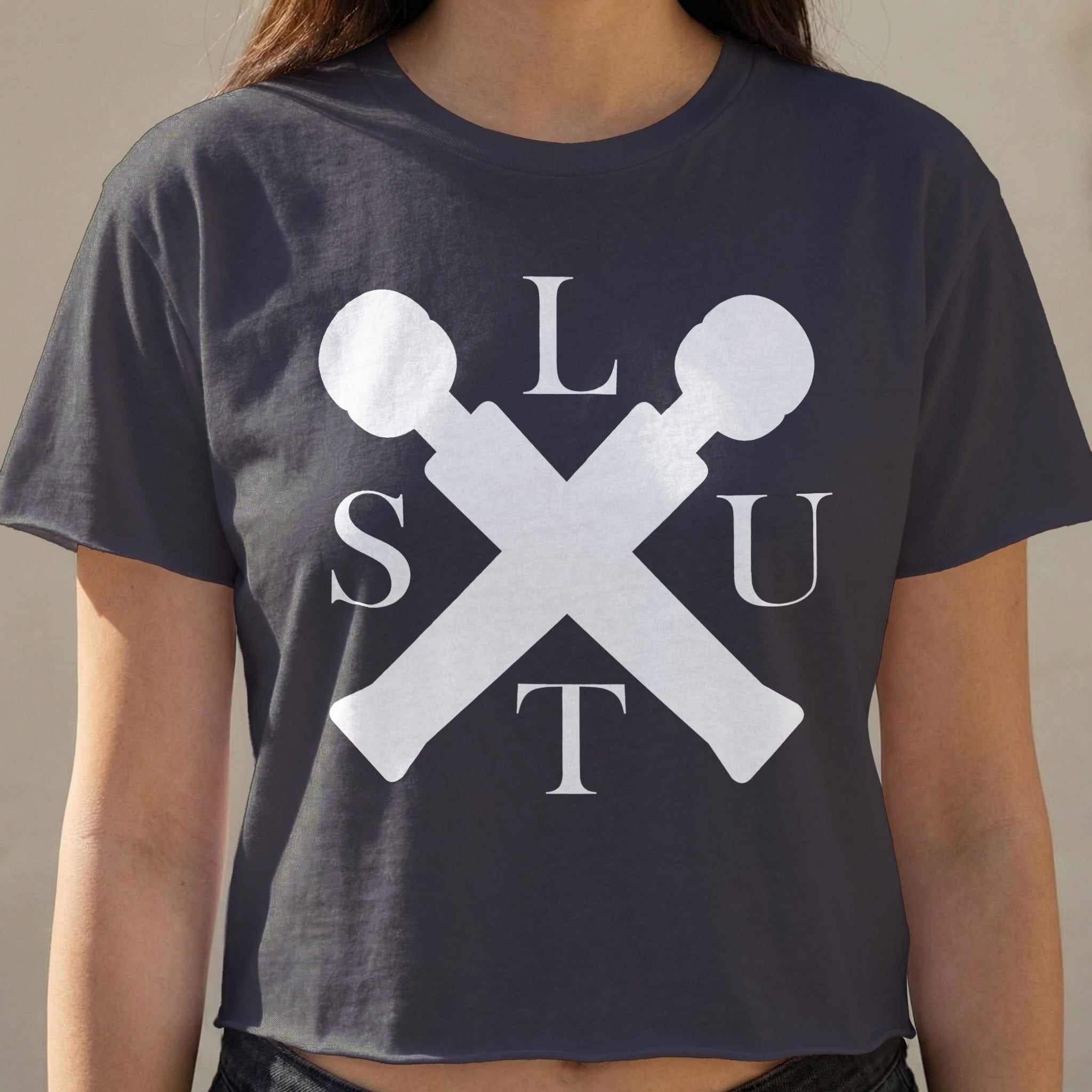 Dark t-shirt with white crossed microphone logo and text "SLUT".