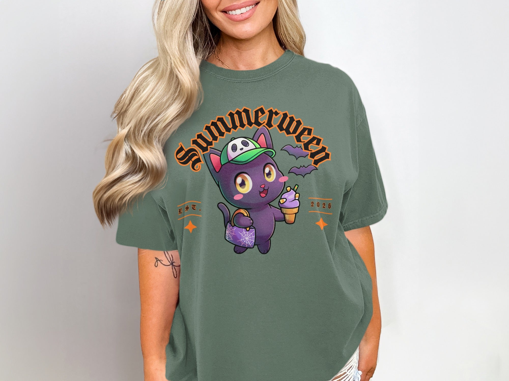 Green t-shirt with "Summerween" text and a cartoon black cat holding ice cream and a bag.