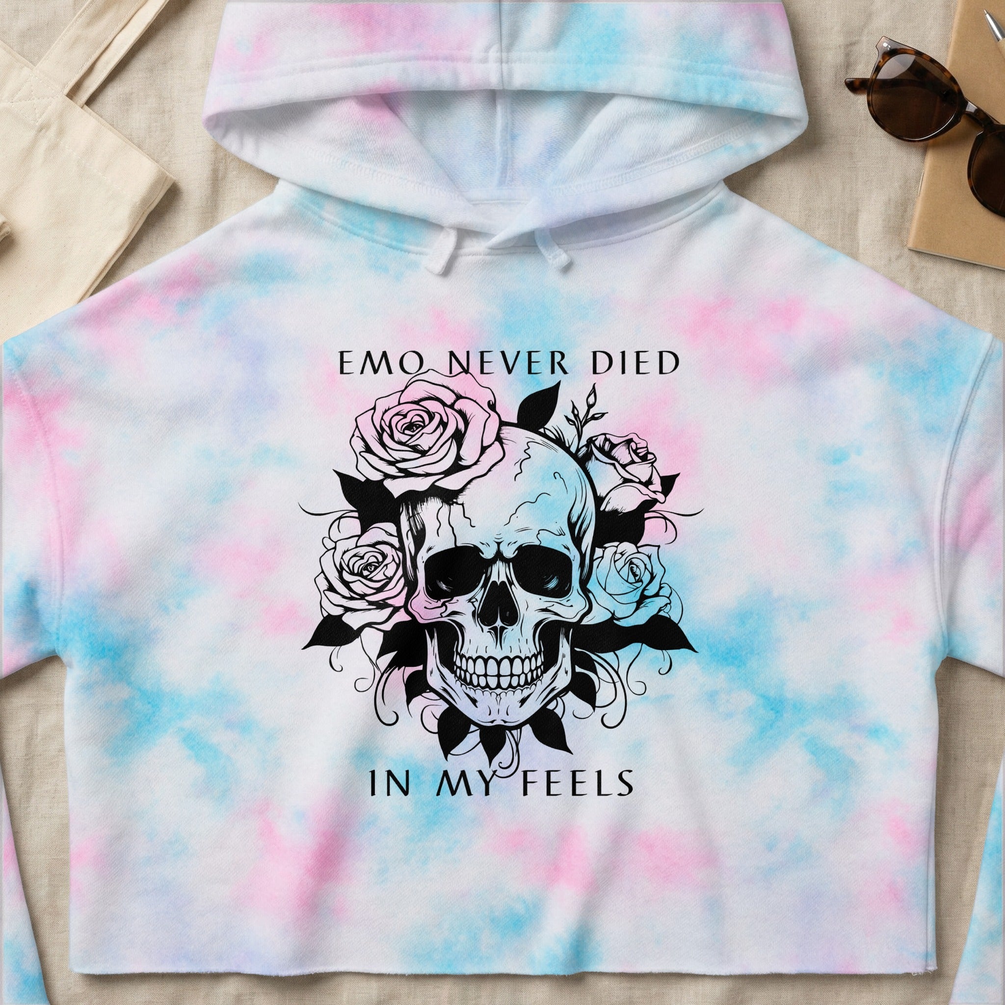 Skull and roses graphic on a tie-dye hoodie reading "EMO NEVER DIED IN MY FEELS".