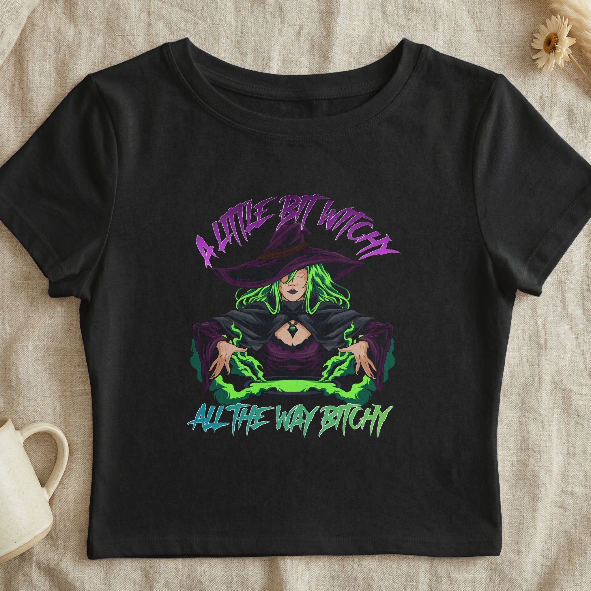 Black t-shirt with graphic of a witch and text "A Little Bit Witchy All The Way Bitchy".