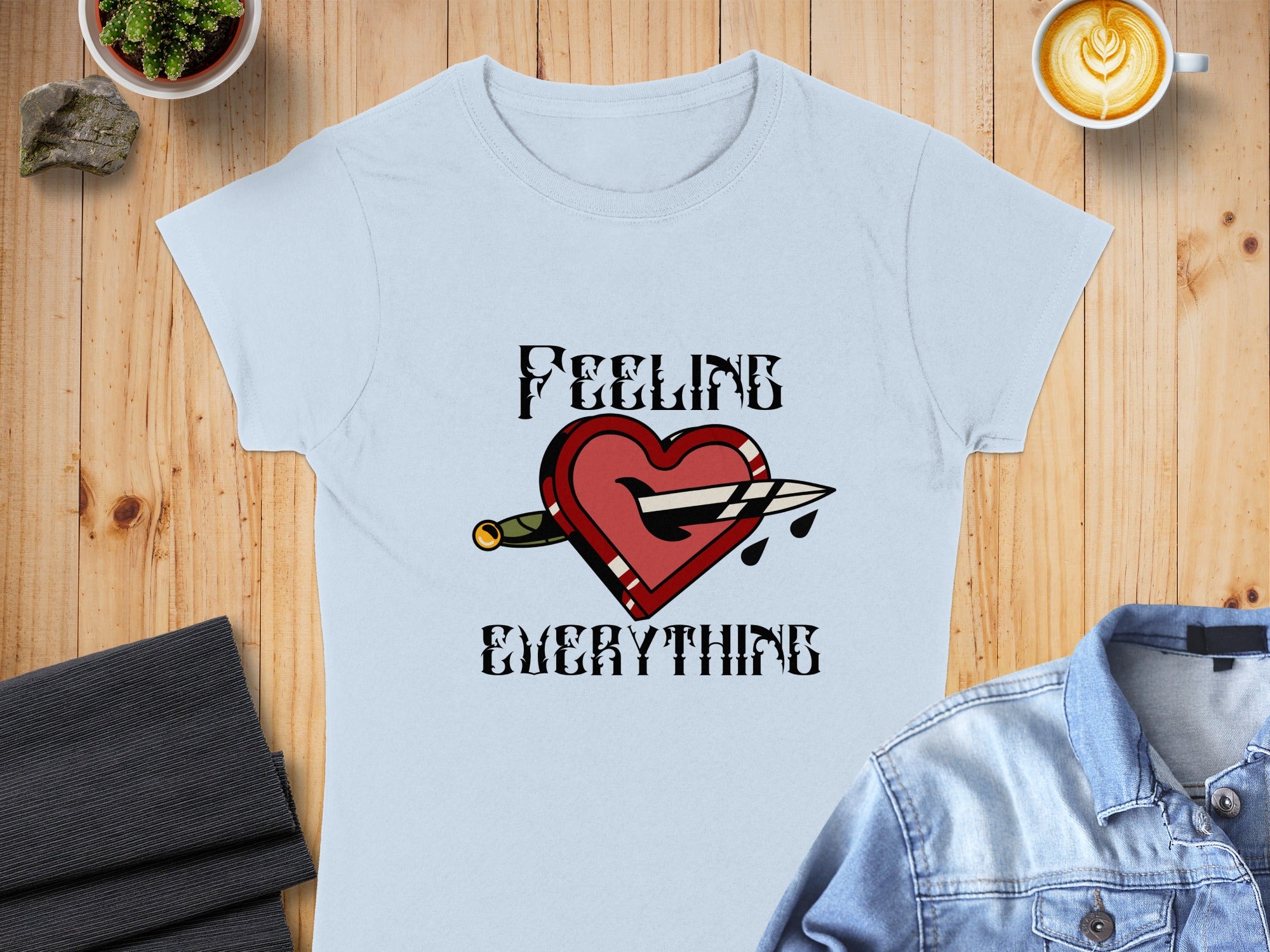 Light blue t-shirt with a dagger through a heart and "FEELING EVERYTHING" text.