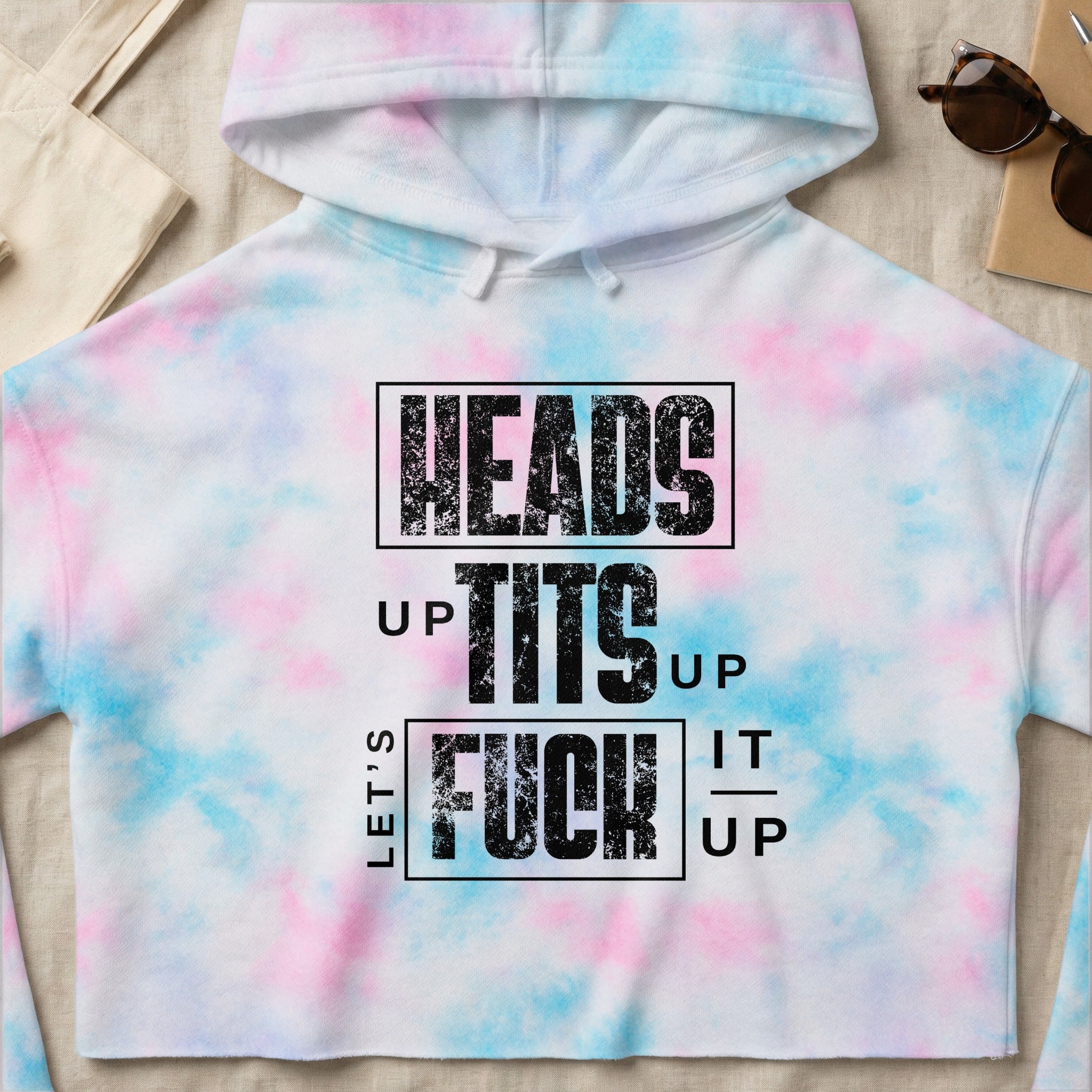 Cropped tie-dye hoodie with bold "HEADS UP TITS UP LET'S FUCK IT UP" text.