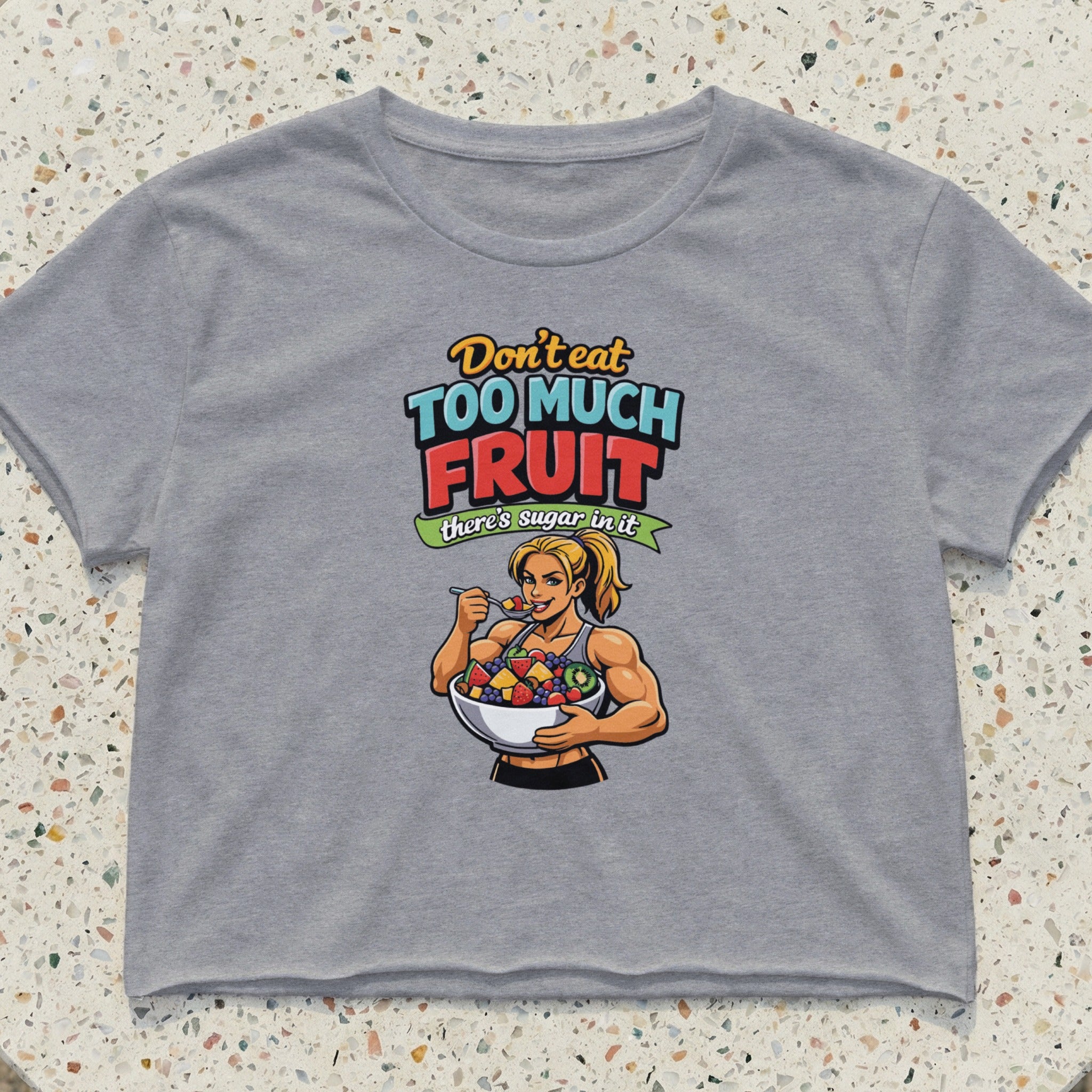 Grey crop top with illustration of fit woman eating fruit salad, text "Don't eat too much sugar there's sugar in it".