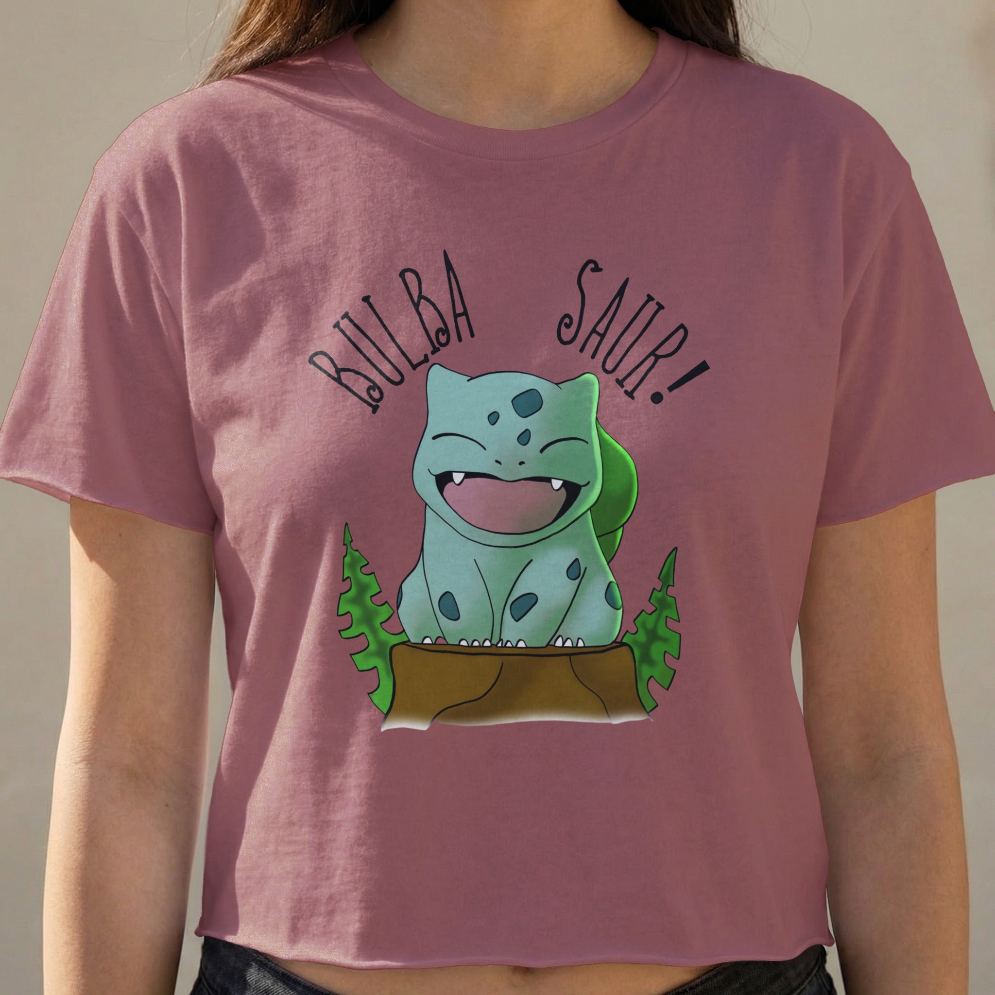 Bulbasaur graphic with "Bulba Saur!" text on a pink cropped t-shirt.