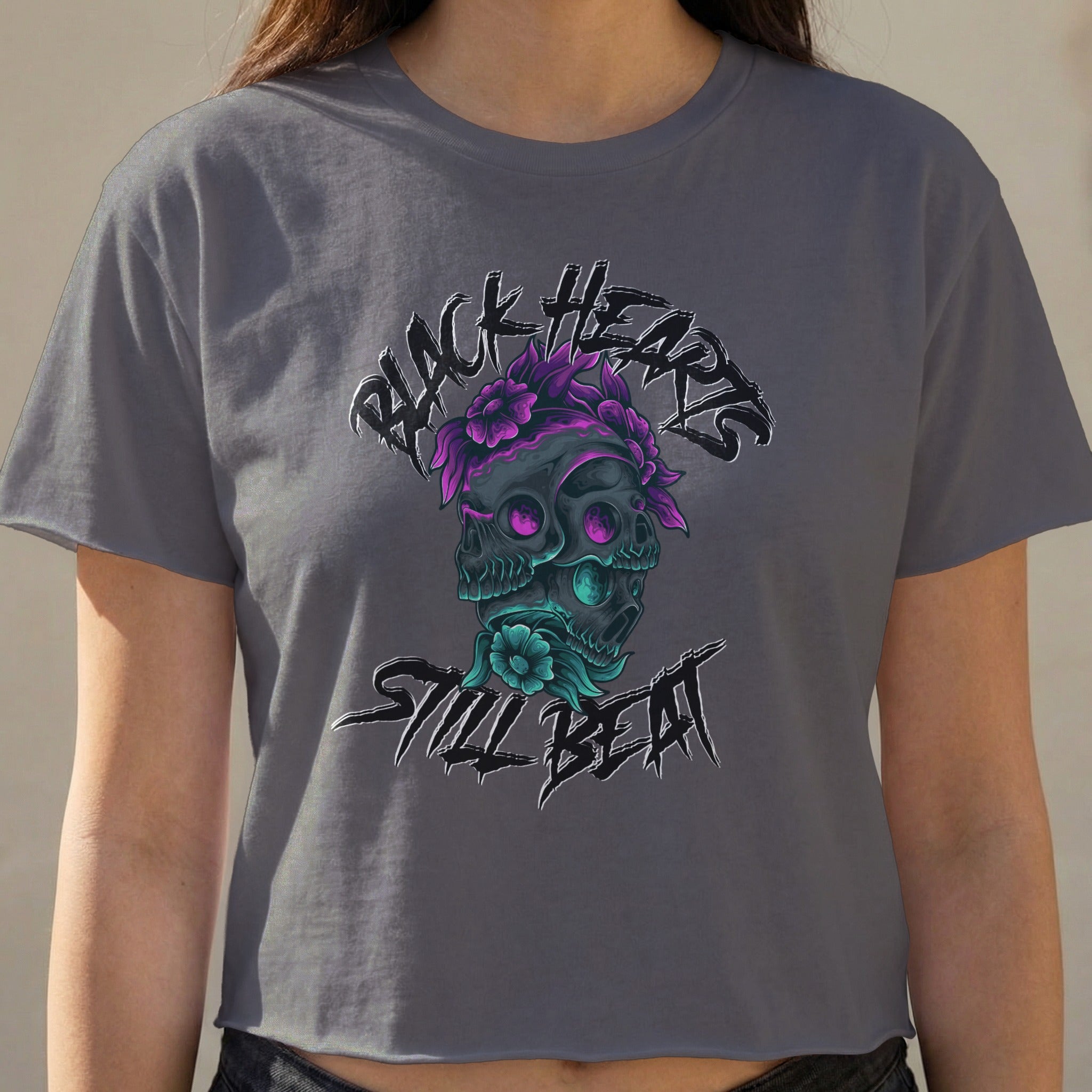Dark grey crop top with a graphic of two skulls adorned with purple flowers.
