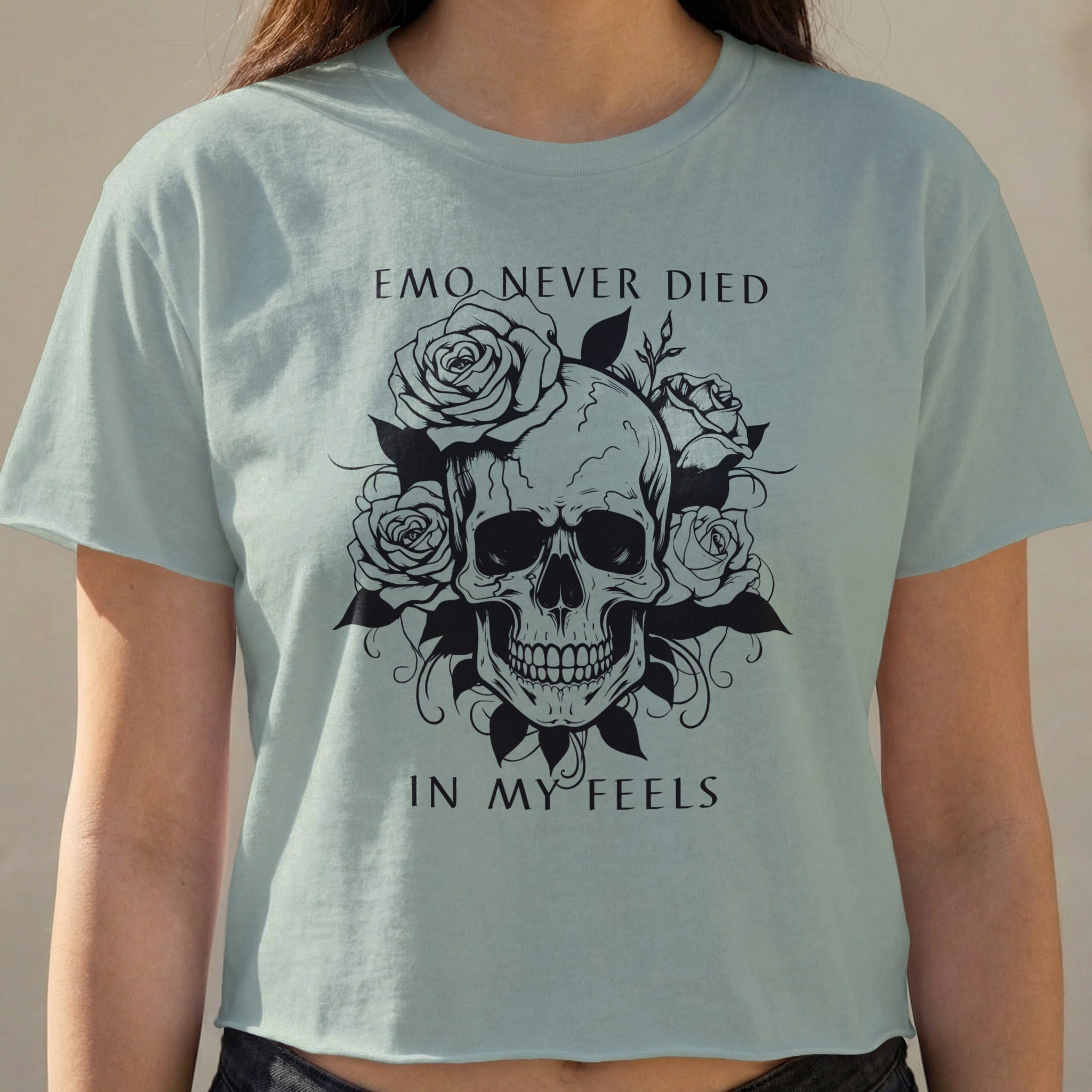Light blue t-shirt with skull and roses graphic and text "EMO NEVER DIED IN MY FEELS".