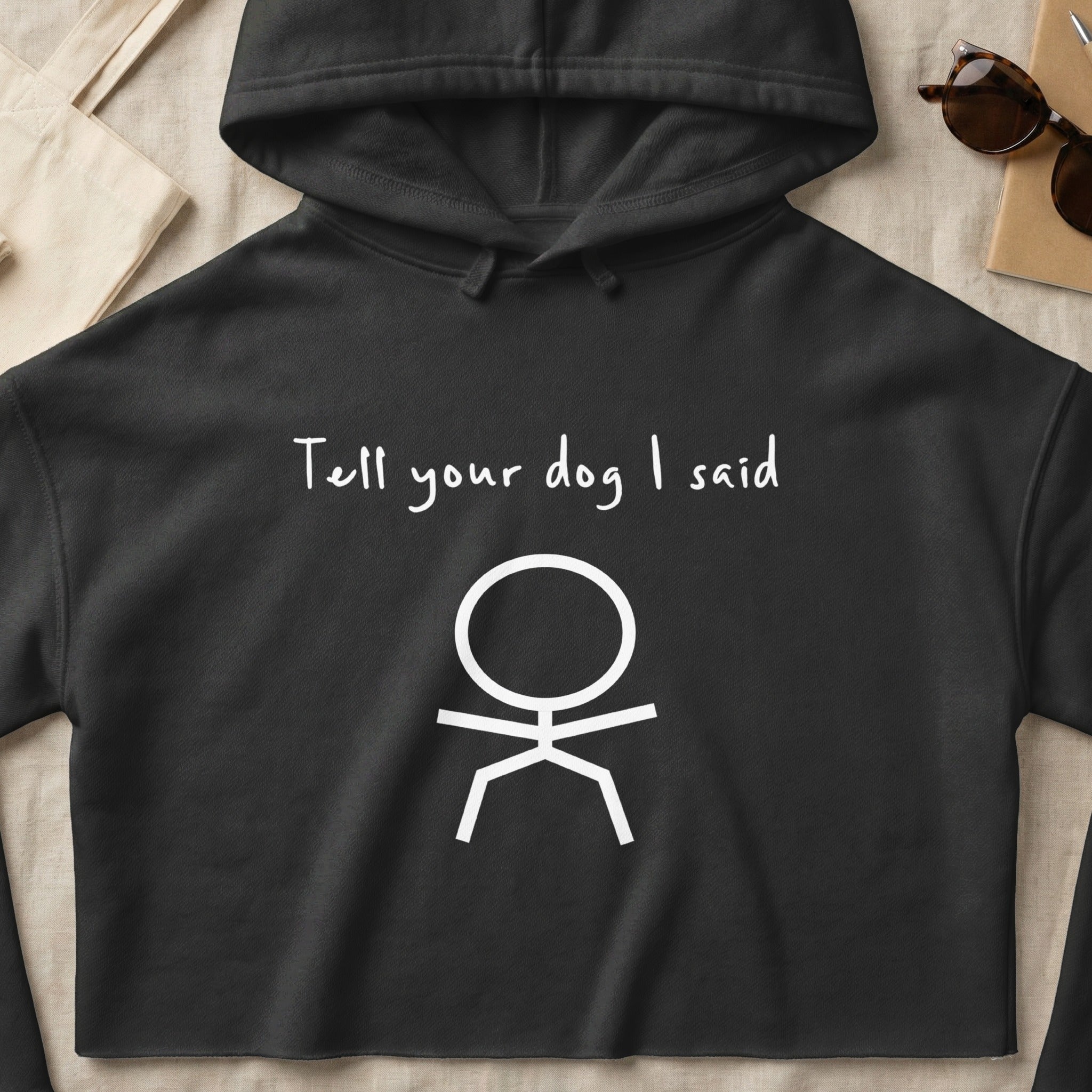 Black hoodie with white text "Tell your dog I said" and a stick figure.
