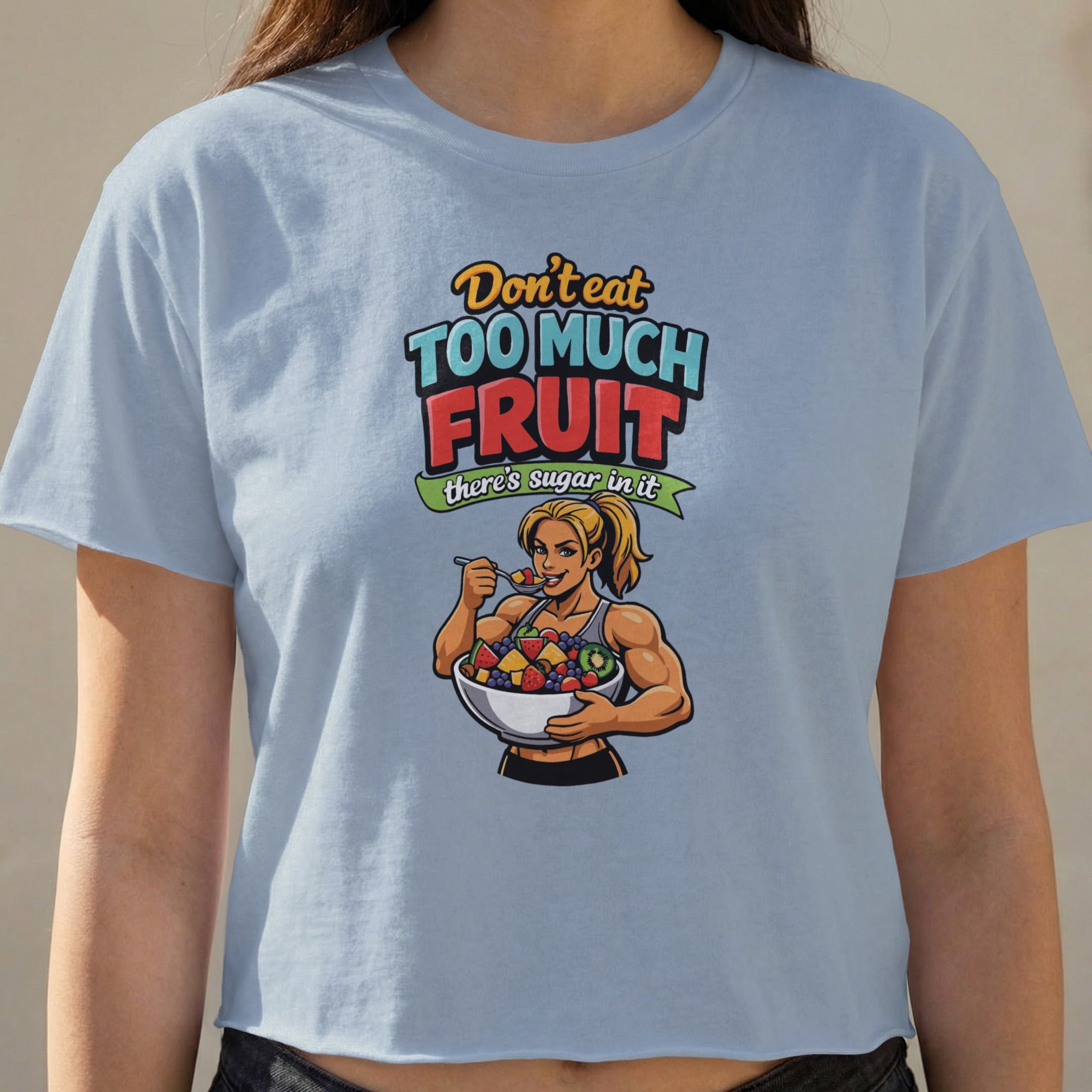 Woman in light blue crop top eating from a bowl of fruit, text reads "Don't eat too much fruit there's sugar in it".