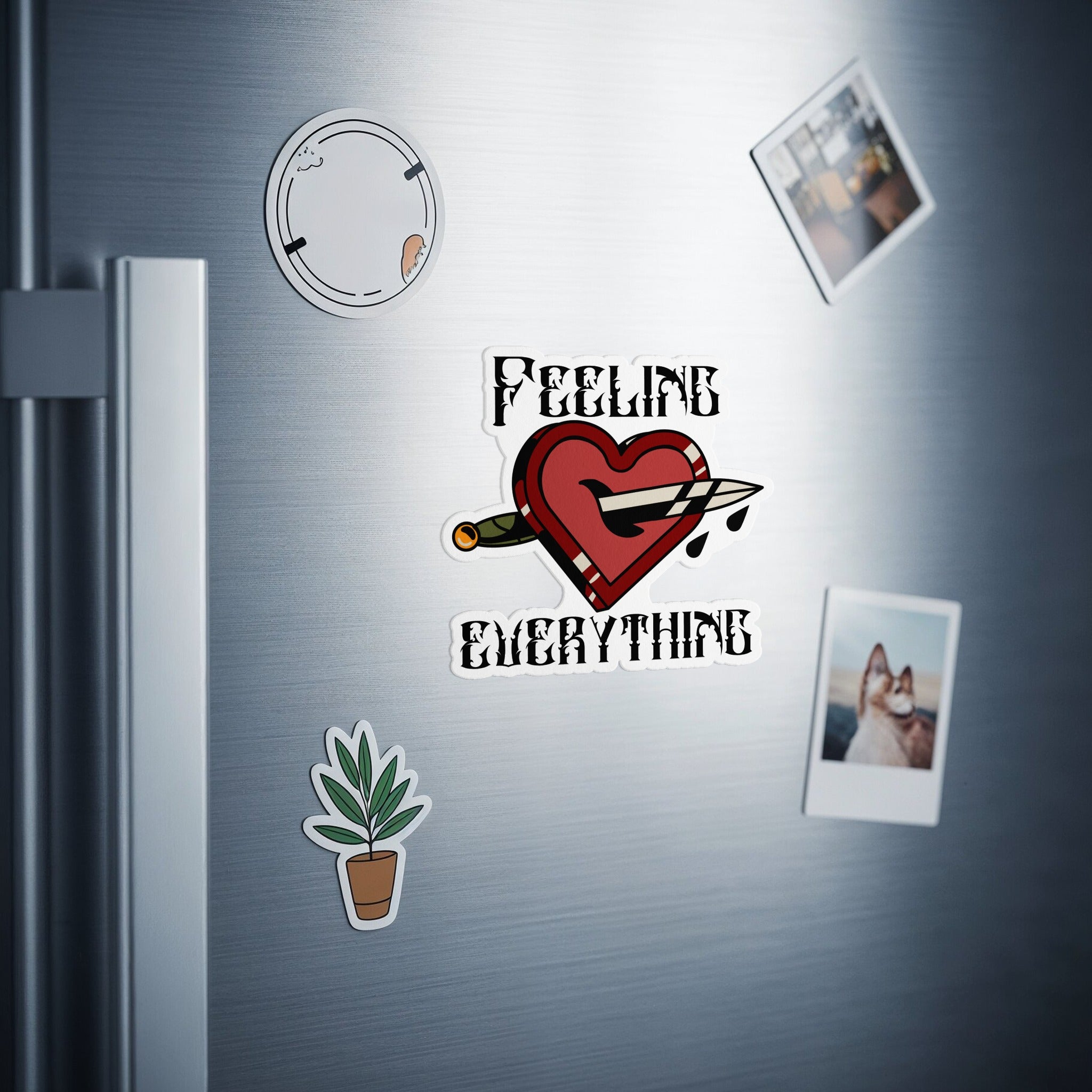 Heart pierced by dagger with text "FEELING EVERYTHING" sticker on refrigerator.