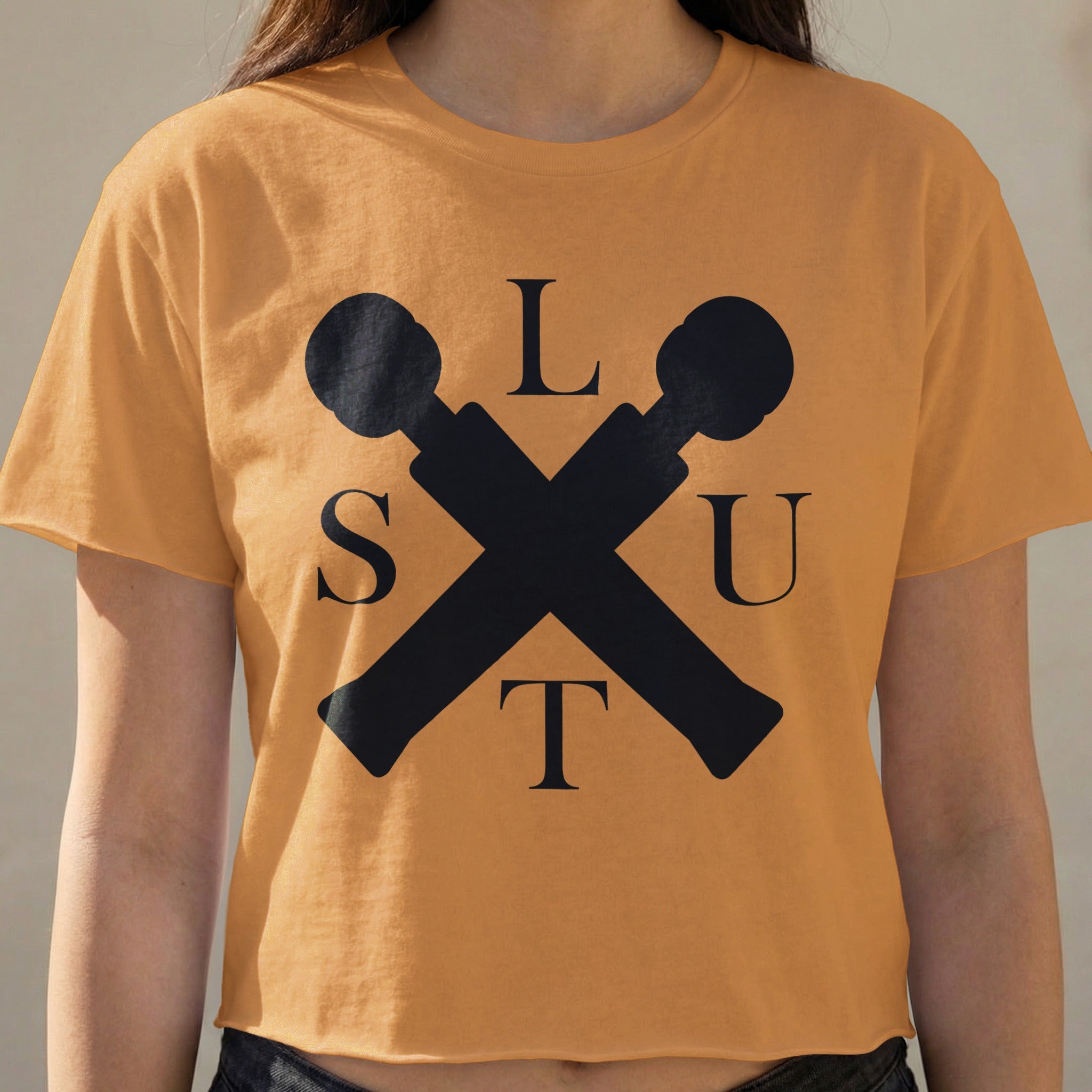 Orange crop top with black crossed microphones forming an "X" and letters S, L, U, T.