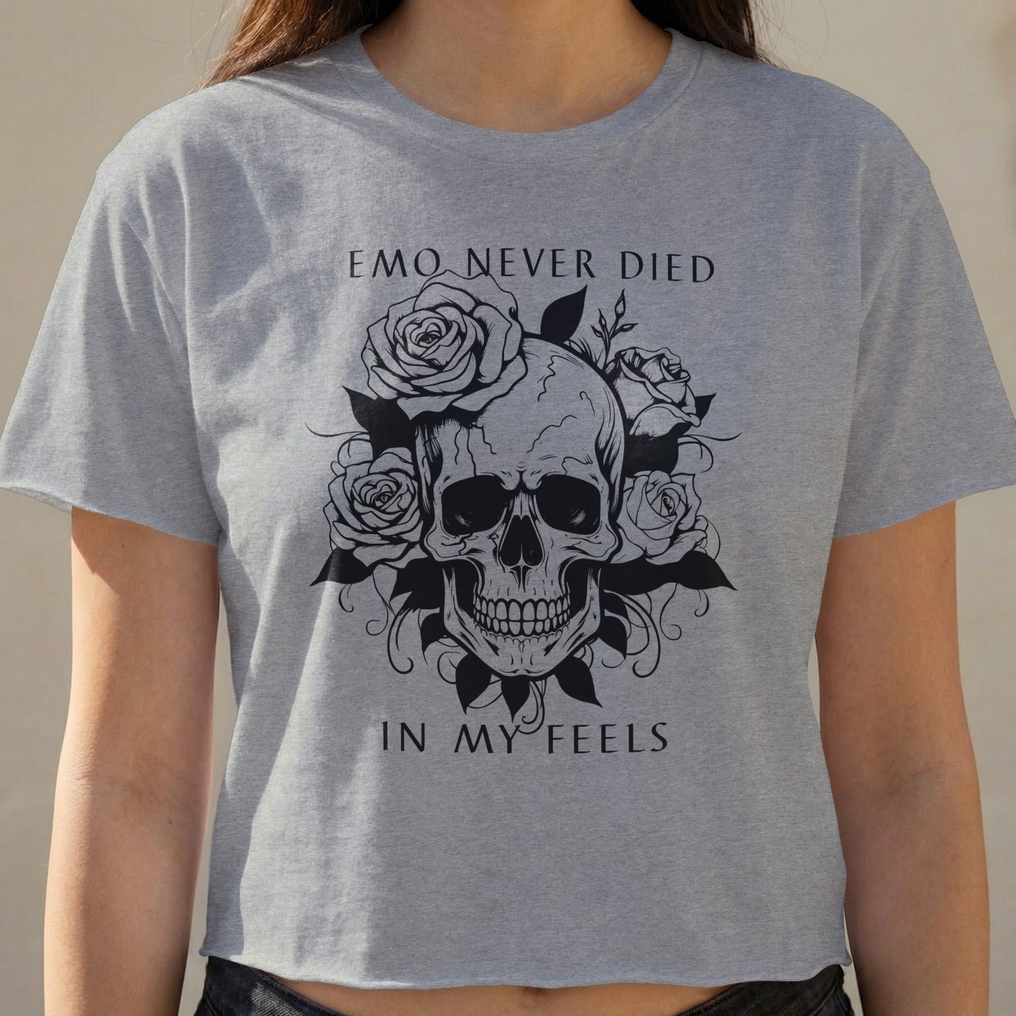 Gray cropped t-shirt with skull and roses graphic and "EMO NEVER DIED IN MY FEELS" text.