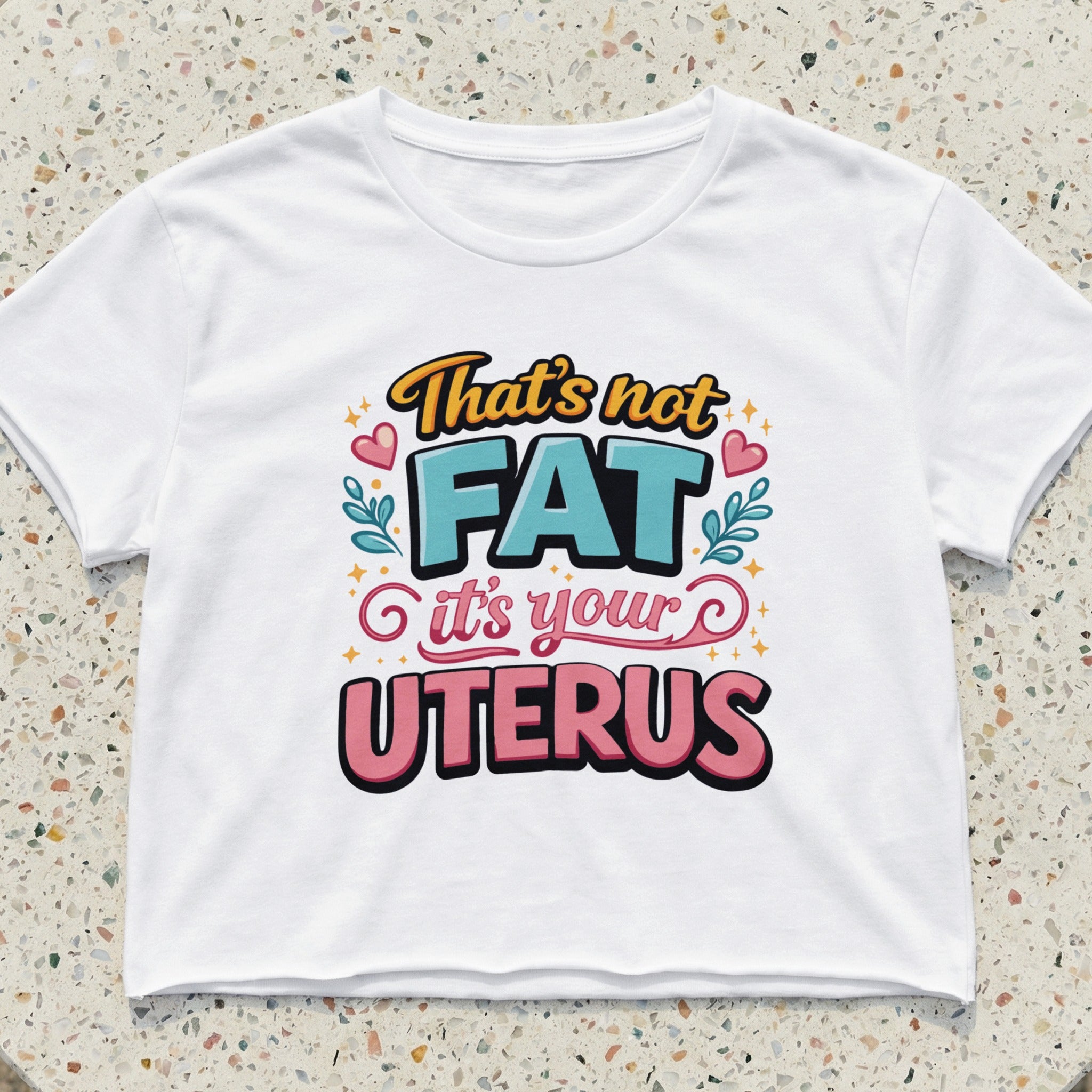 White crop top with "That's not FAT it's your UTERUS" text and decorative elements.