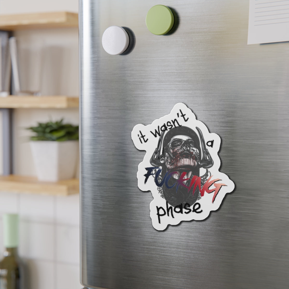 Sticker with "it wasn't a phase" text and skull graphic on a refrigerator.