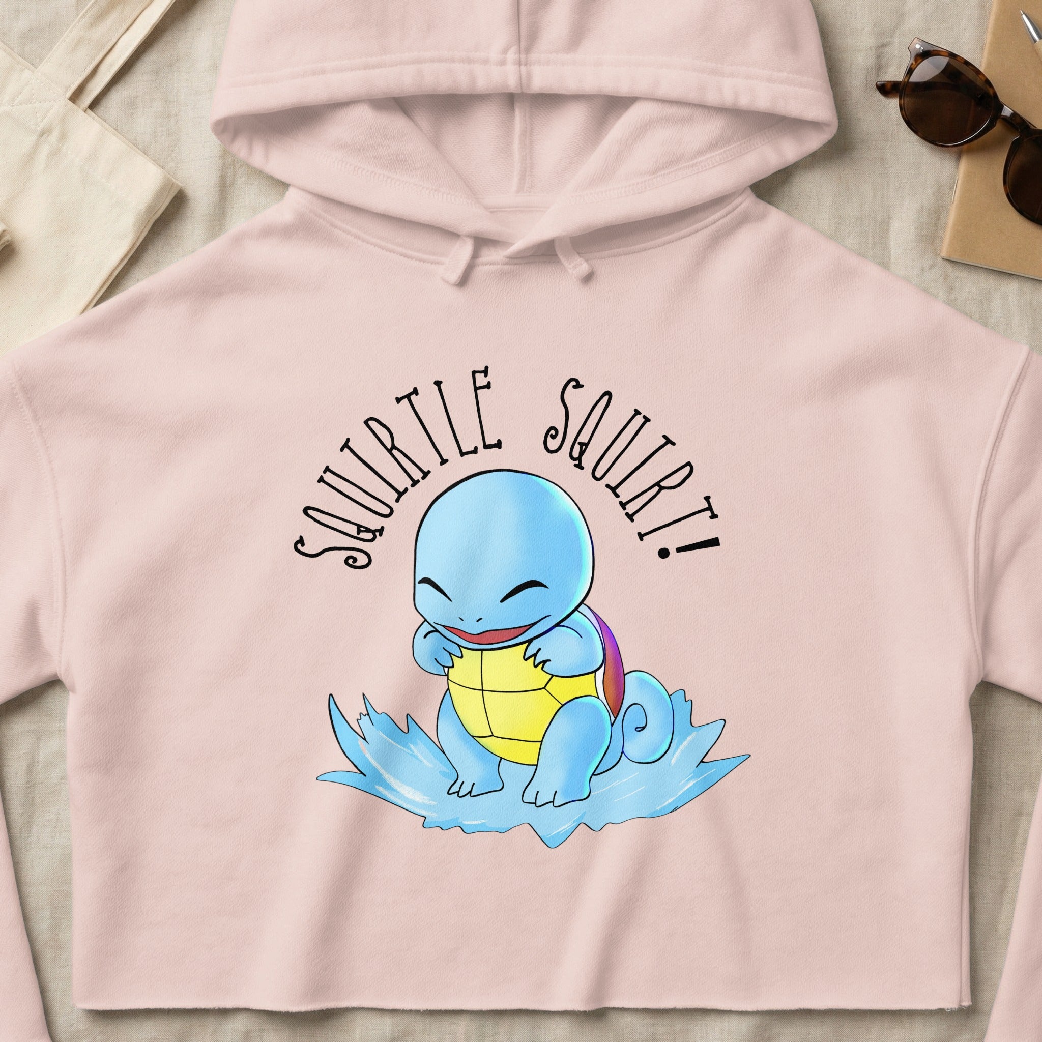 Pink crop hoodie with Squirtle character and text "SQUIRTLE SQUIRT!".