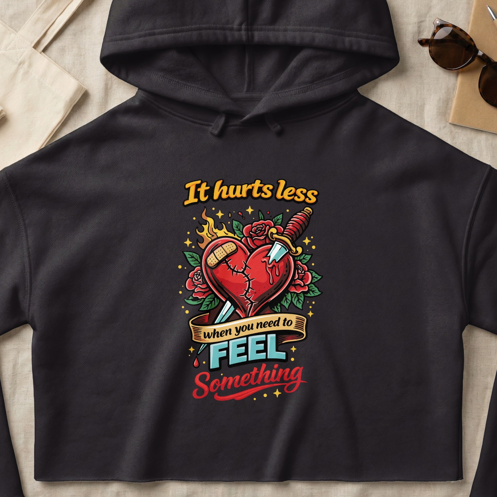 Black hoodie with a graphic of a broken heart pierced by a dagger.