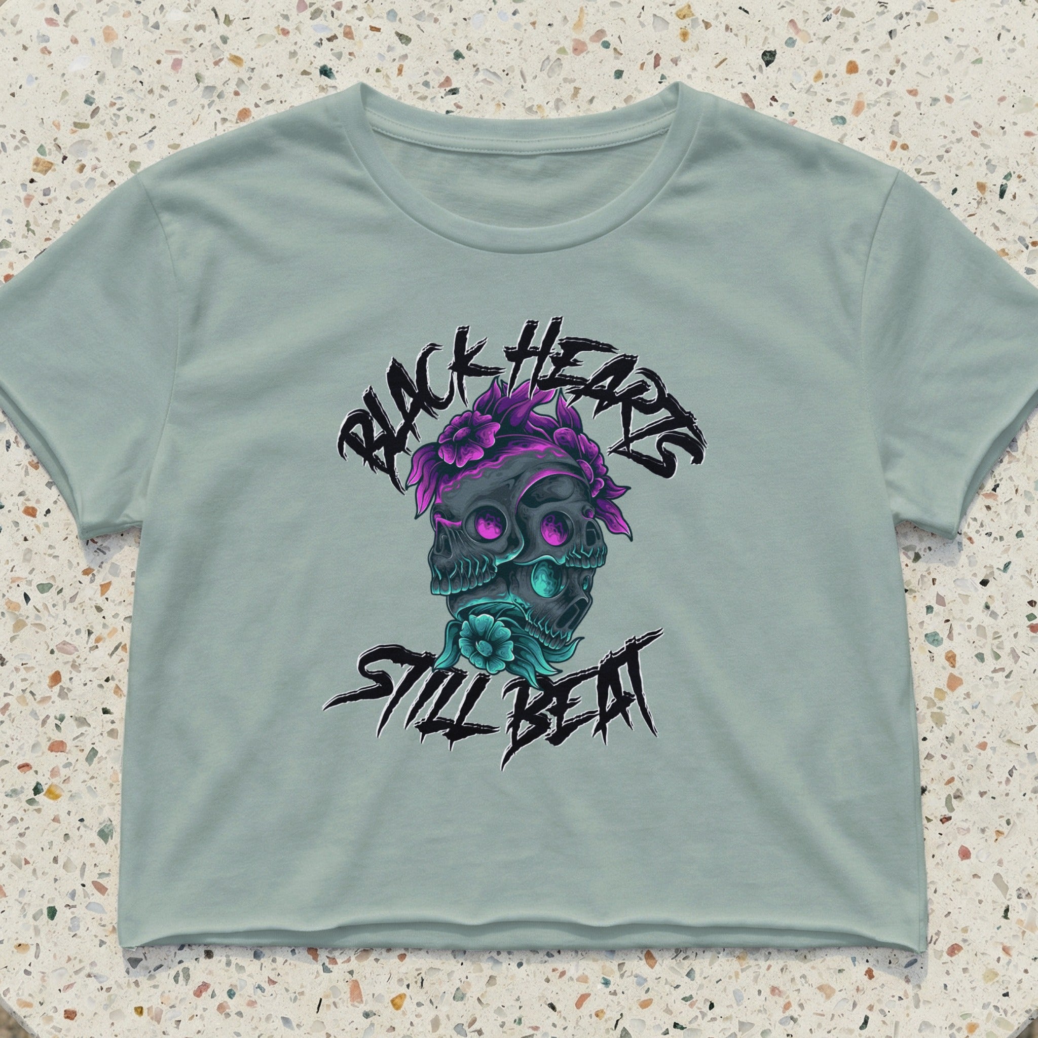 Crop top with two skulls, purple flowers, and text "BLACK HEARTS STILL BEAT".