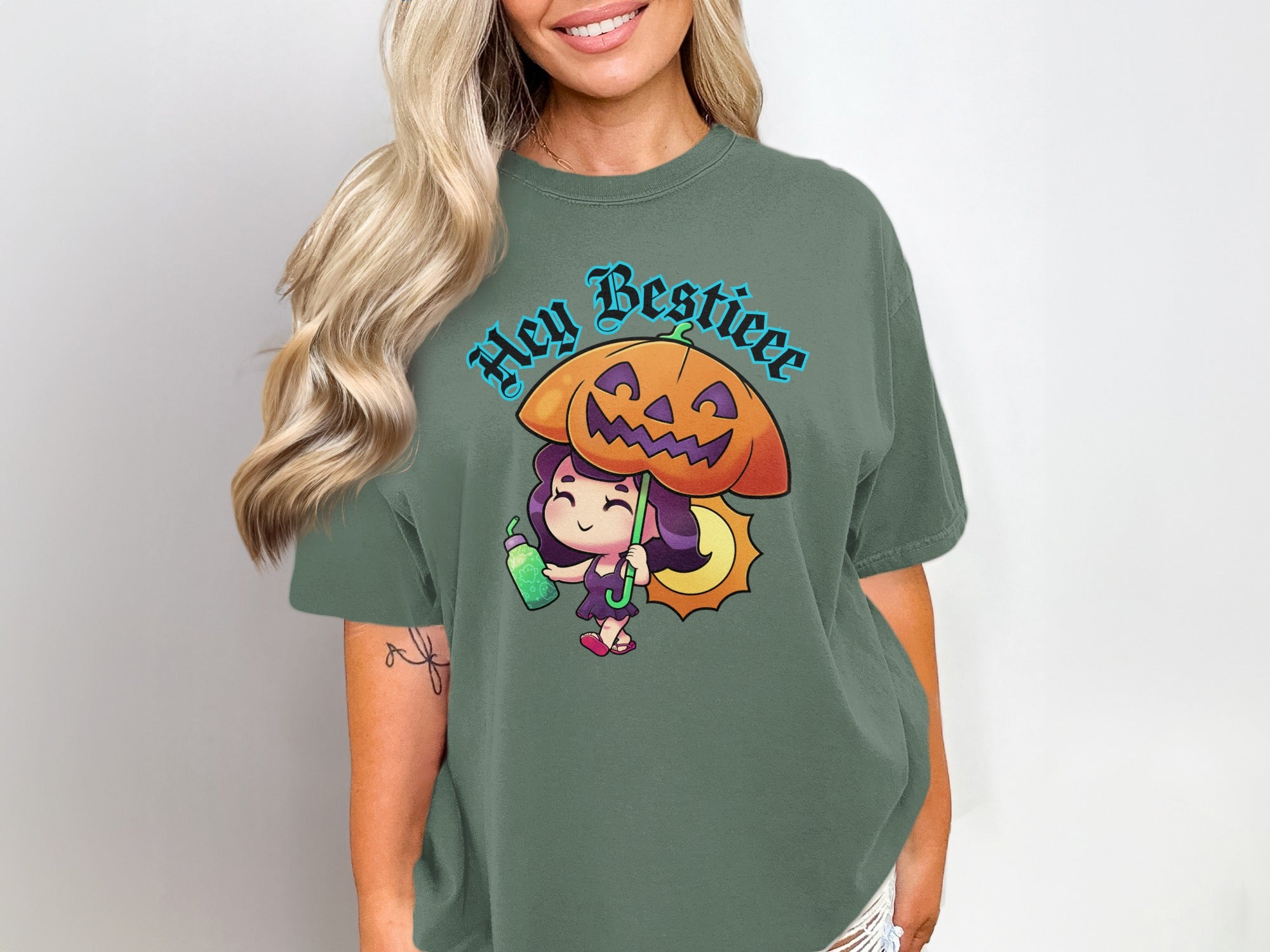 Green t-shirt with "Hey Bestieee" and a cartoon girl holding a pumpkin umbrella.