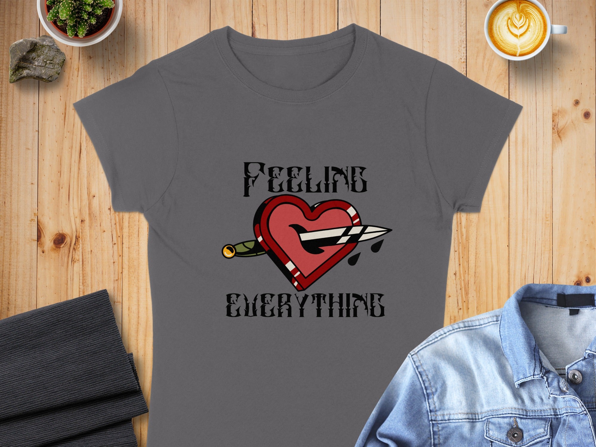 Grey t-shirt with "FEELING EVERYTHING" text and pierced heart graphic.