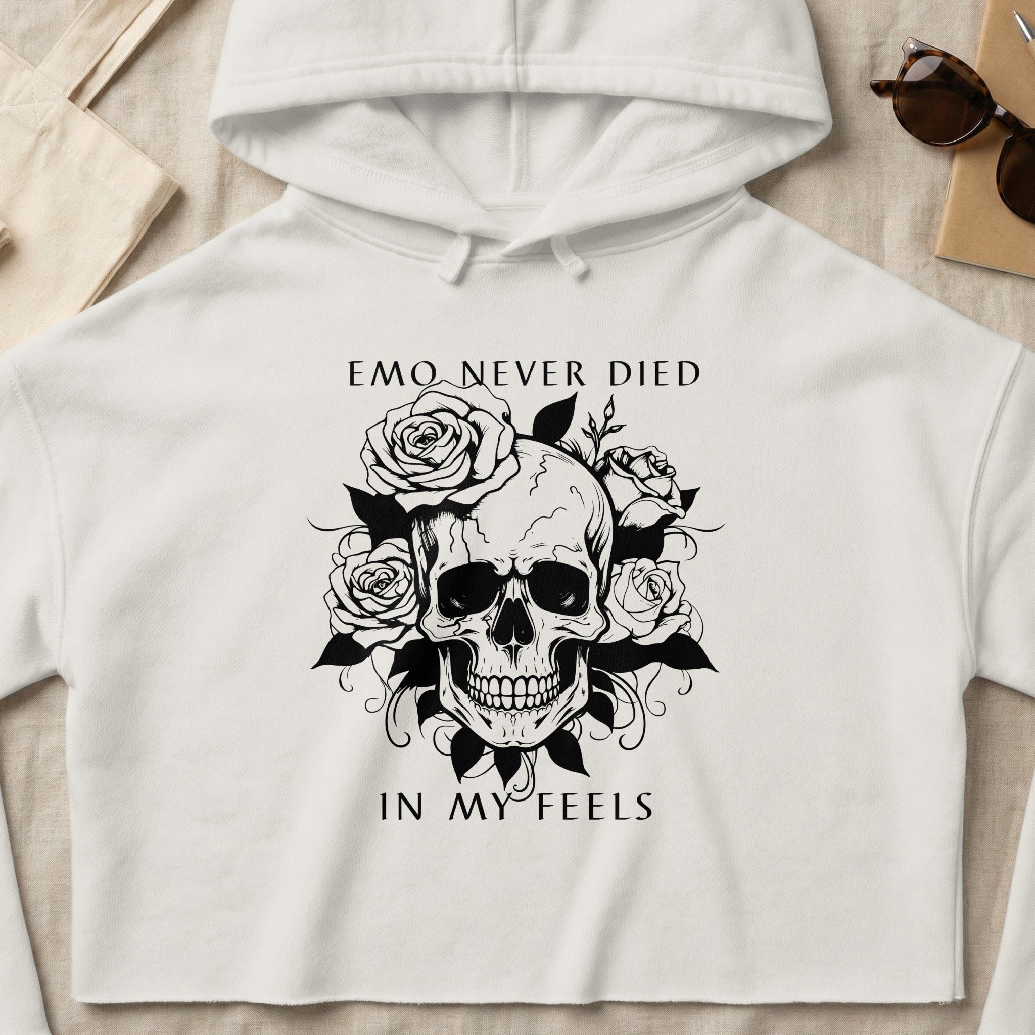 White cropped hoodie with black skull and rose graphic and text "EMO NEVER DIED IN MY FEELS".