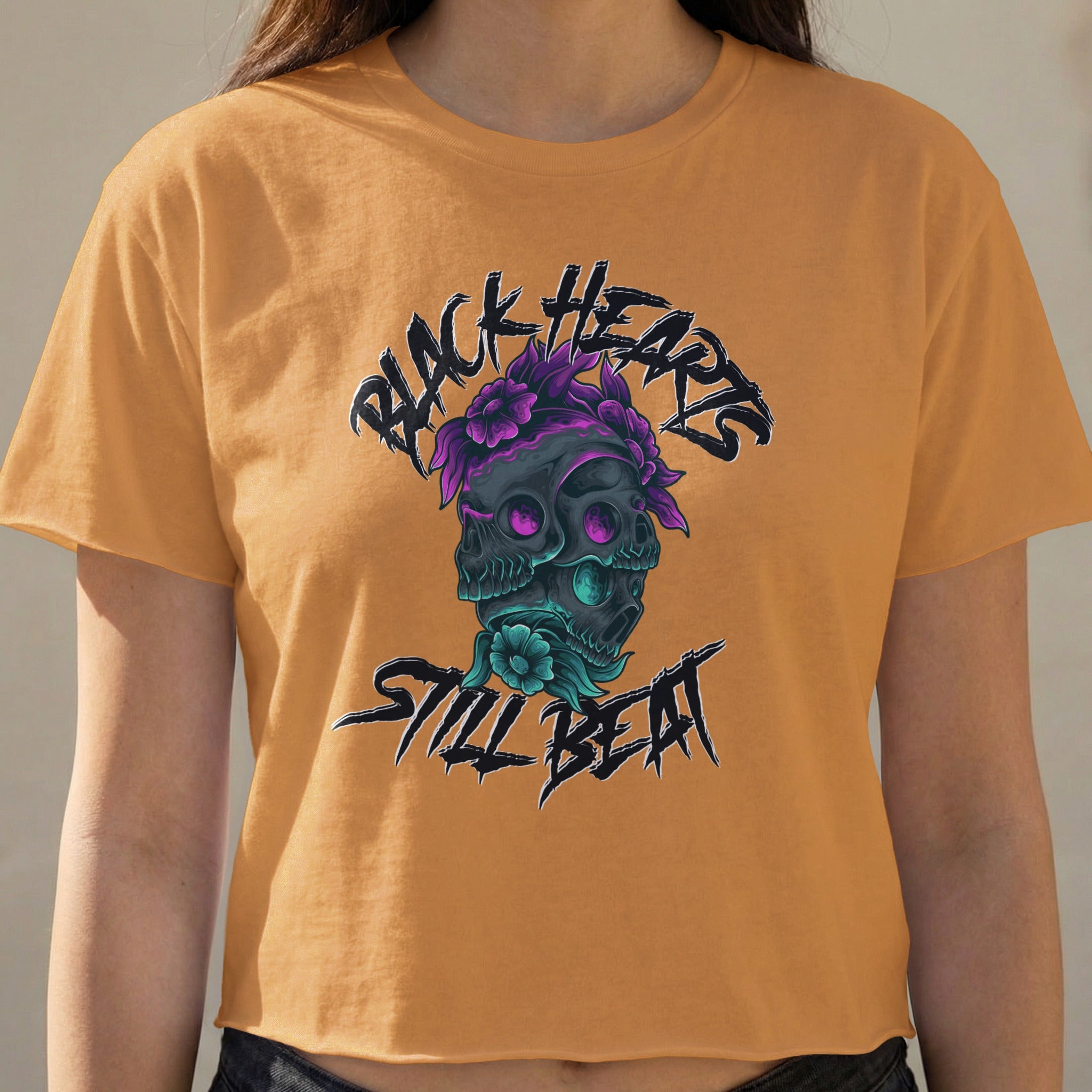 Orange crop top with a black heart, skull, and floral design.