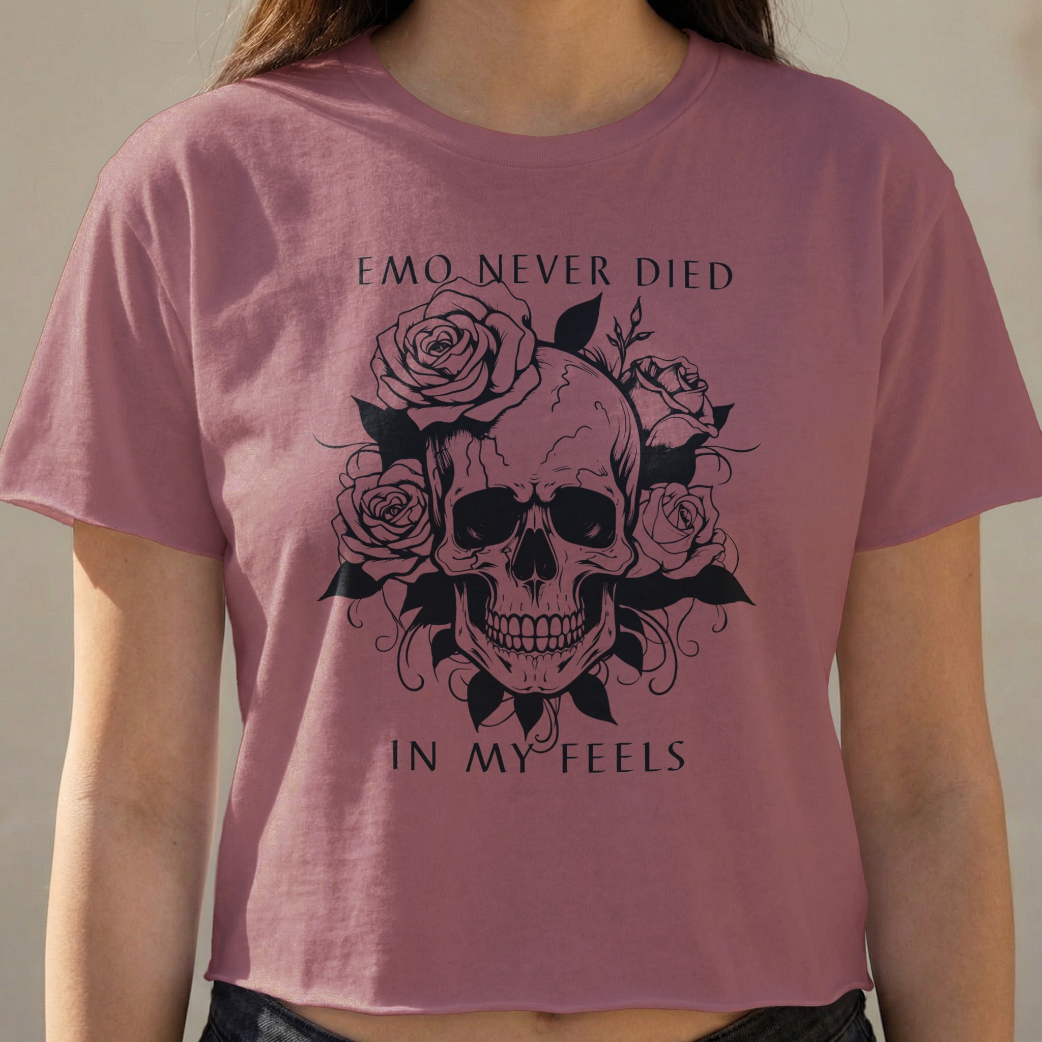 Pink t-shirt with skull and roses graphic, text reads "EMO NEVER DIED IN MY FEELS".