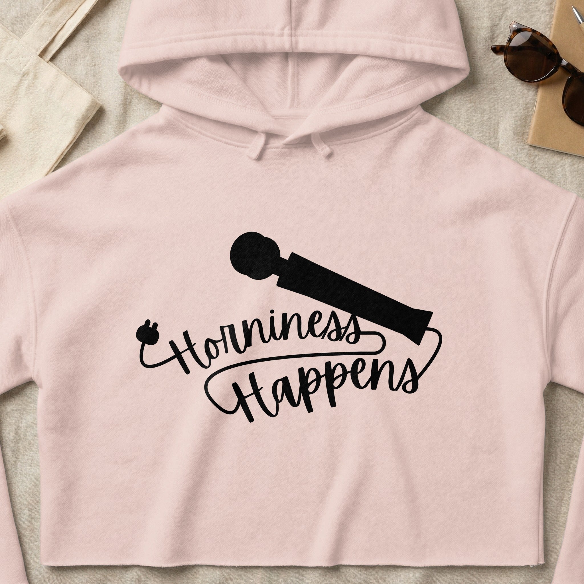 Pink cropped hoodie with "Horniness Happens" text and a wand graphic.