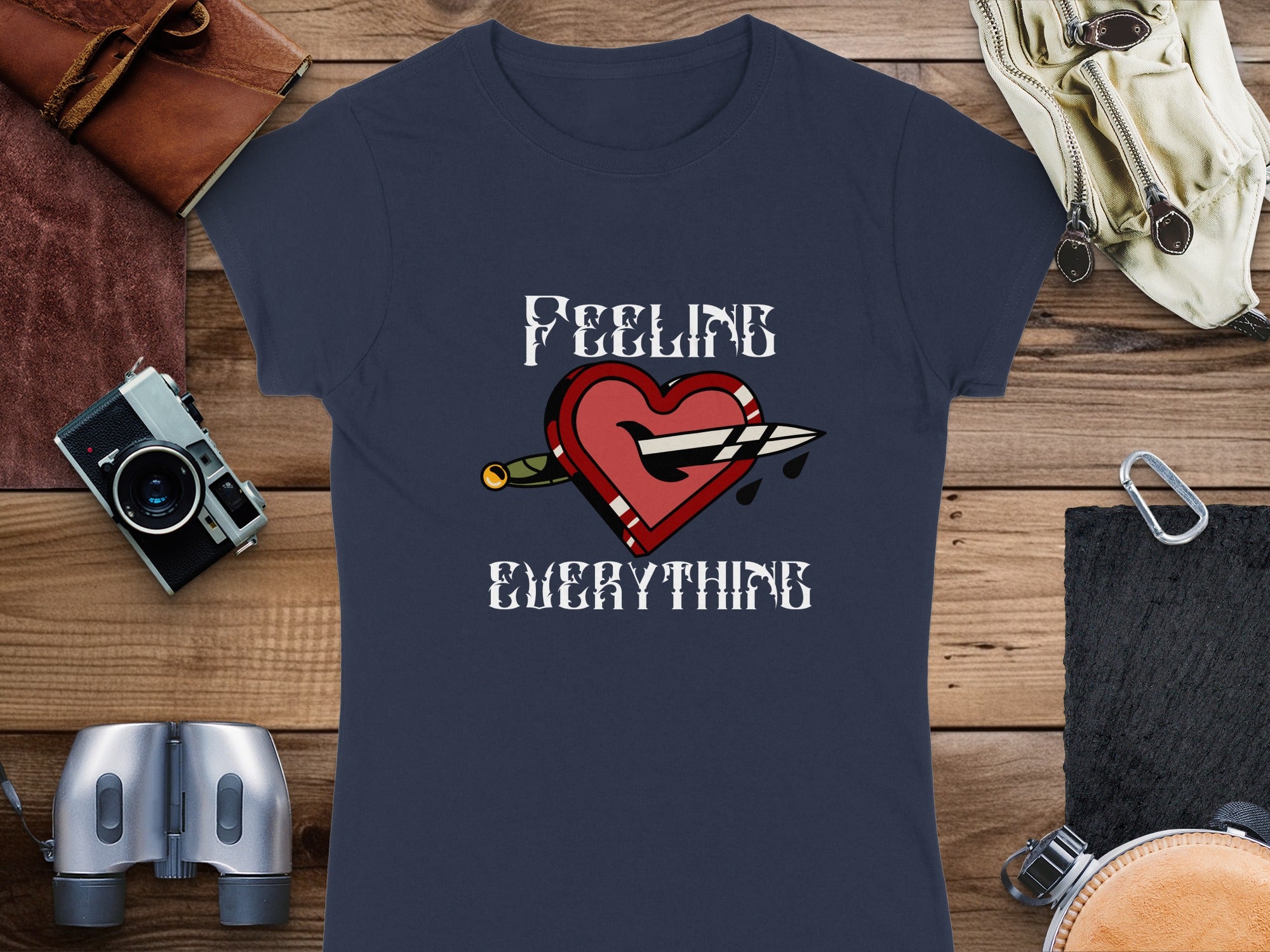 Navy t-shirt with "FEELING EVERYTHING" and a broken heart pierced by a dagger.