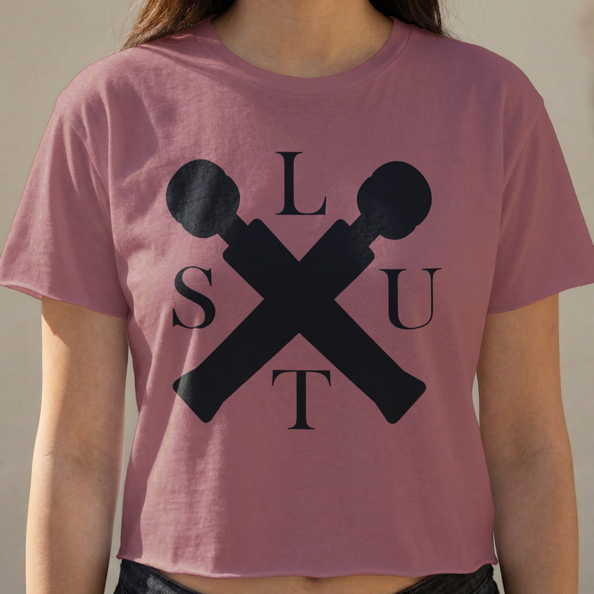 Cropped t-shirt with black "SLUT" logo formed by crossed microphones.