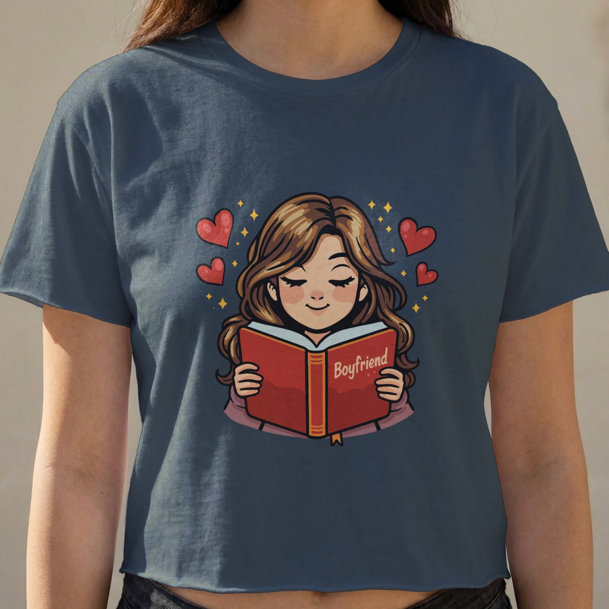 Woman wearing a navy blue t-shirt, reading a book titled "Boyfriend" with hearts.