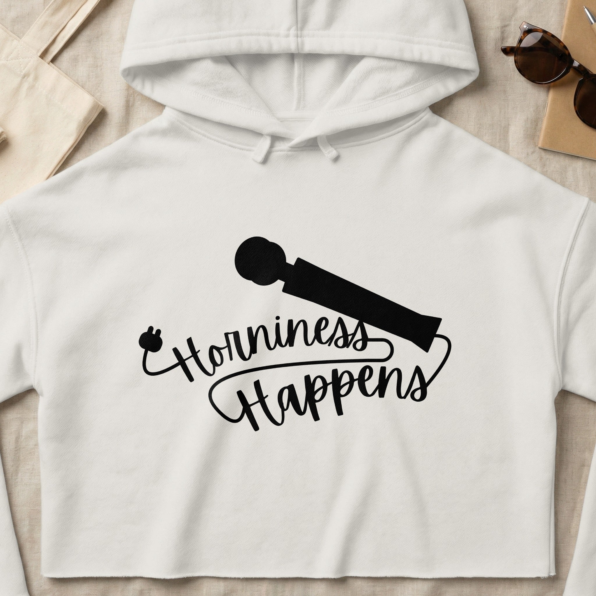 White cropped hoodie with "Horniness Happens" text and a wand illustration.