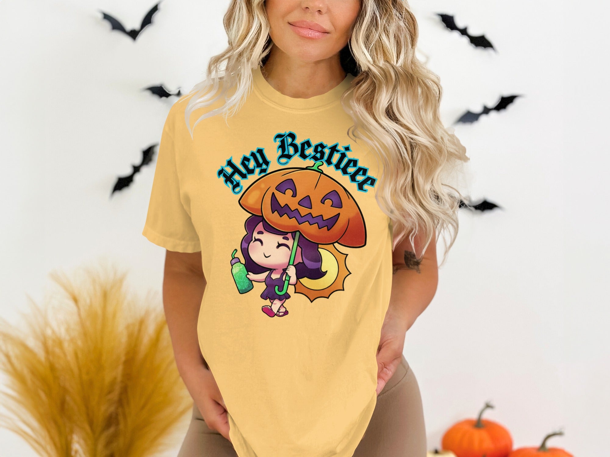 Yellow t-shirt with cartoon girl holding pumpkin umbrella and text "Hey Bestieee".