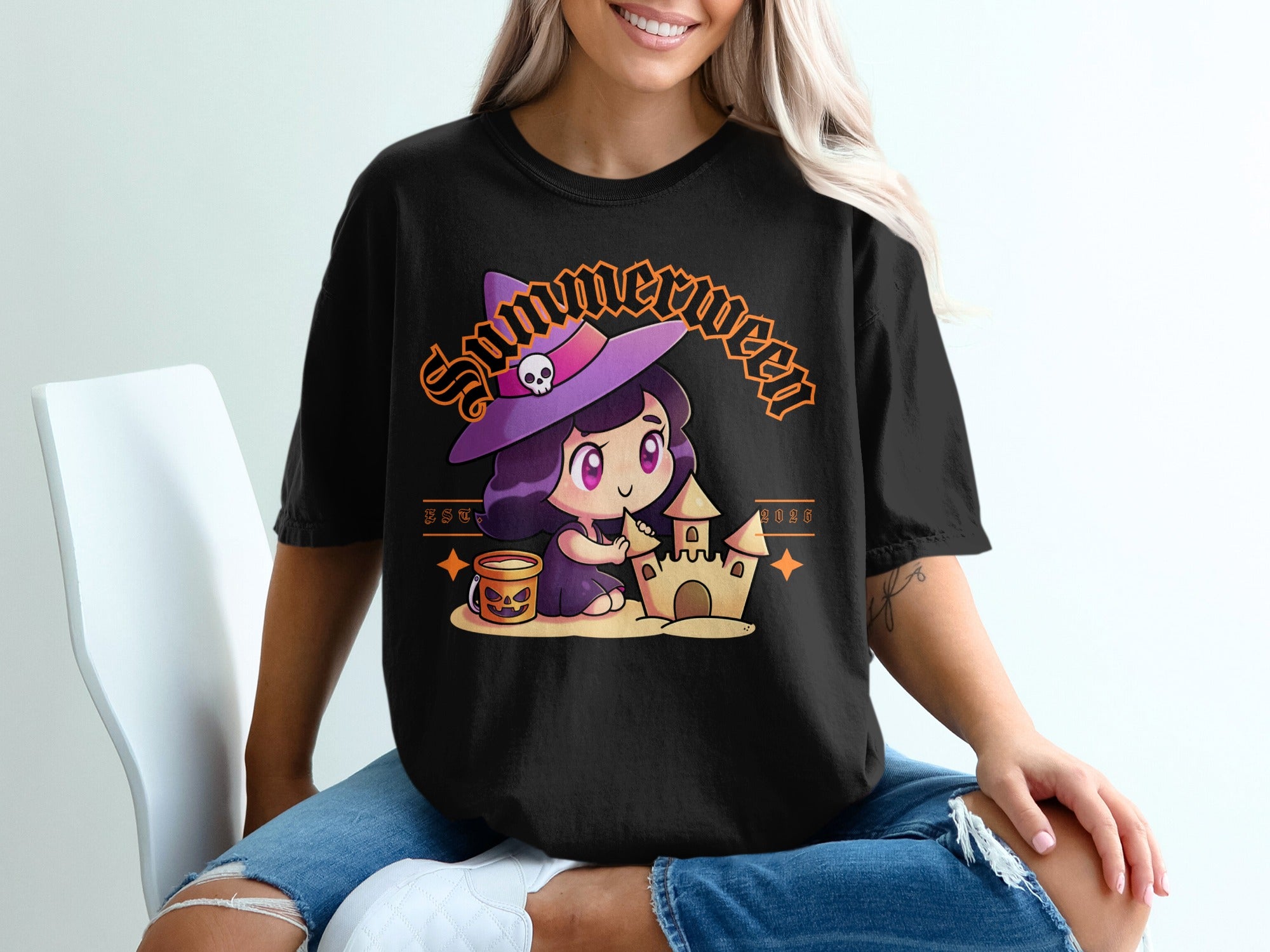 Black t-shirt with a cute witch building a sandcastle with "Summerween EST. 2026" text.