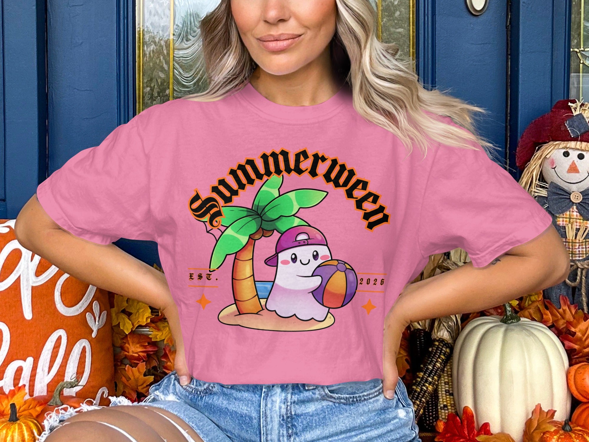Pink t-shirt with a cartoon ghost playing beach ball under a palm tree, "Summerween EST 2026".