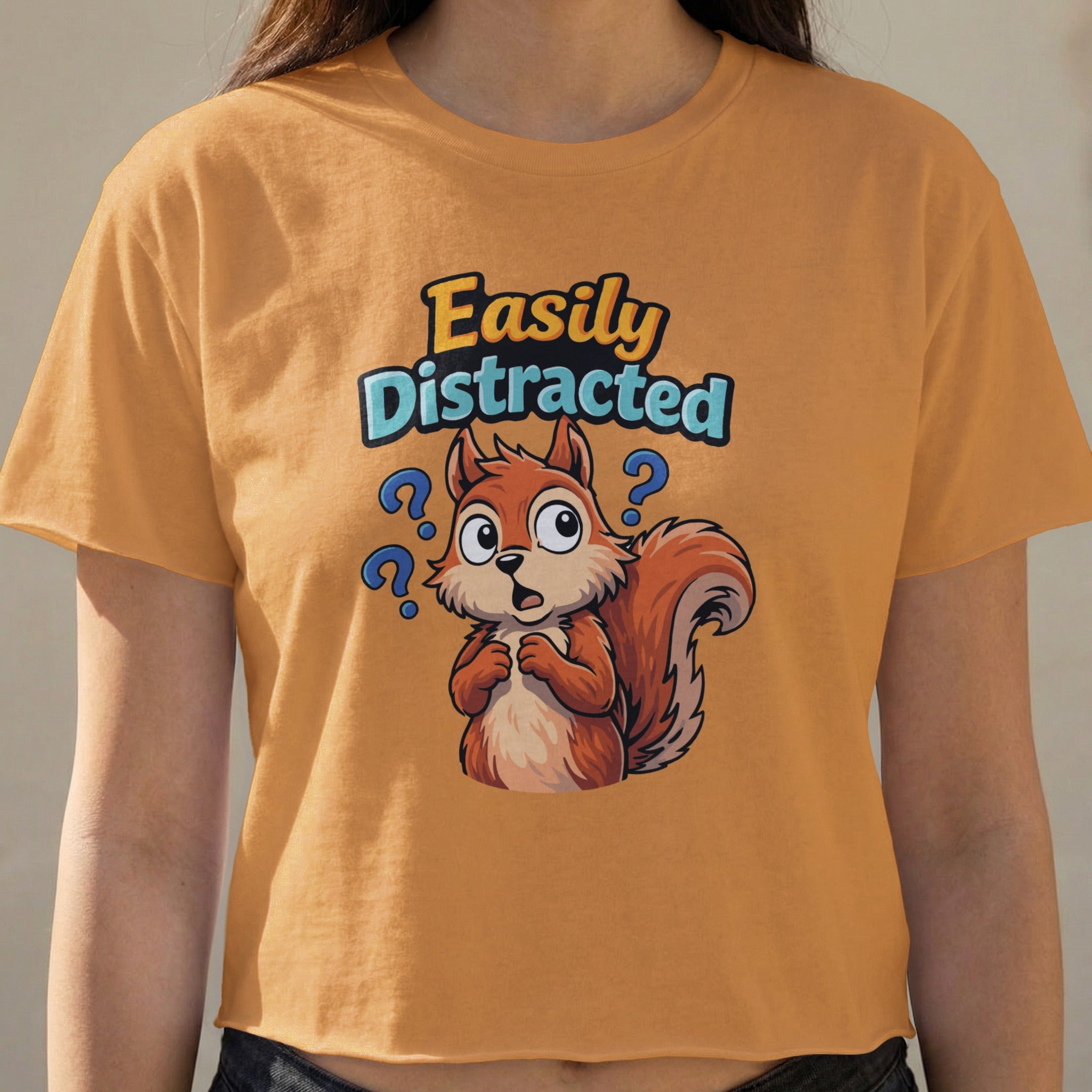 Orange t-shirt with a cartoon squirrel and "Easily Distracted" text.