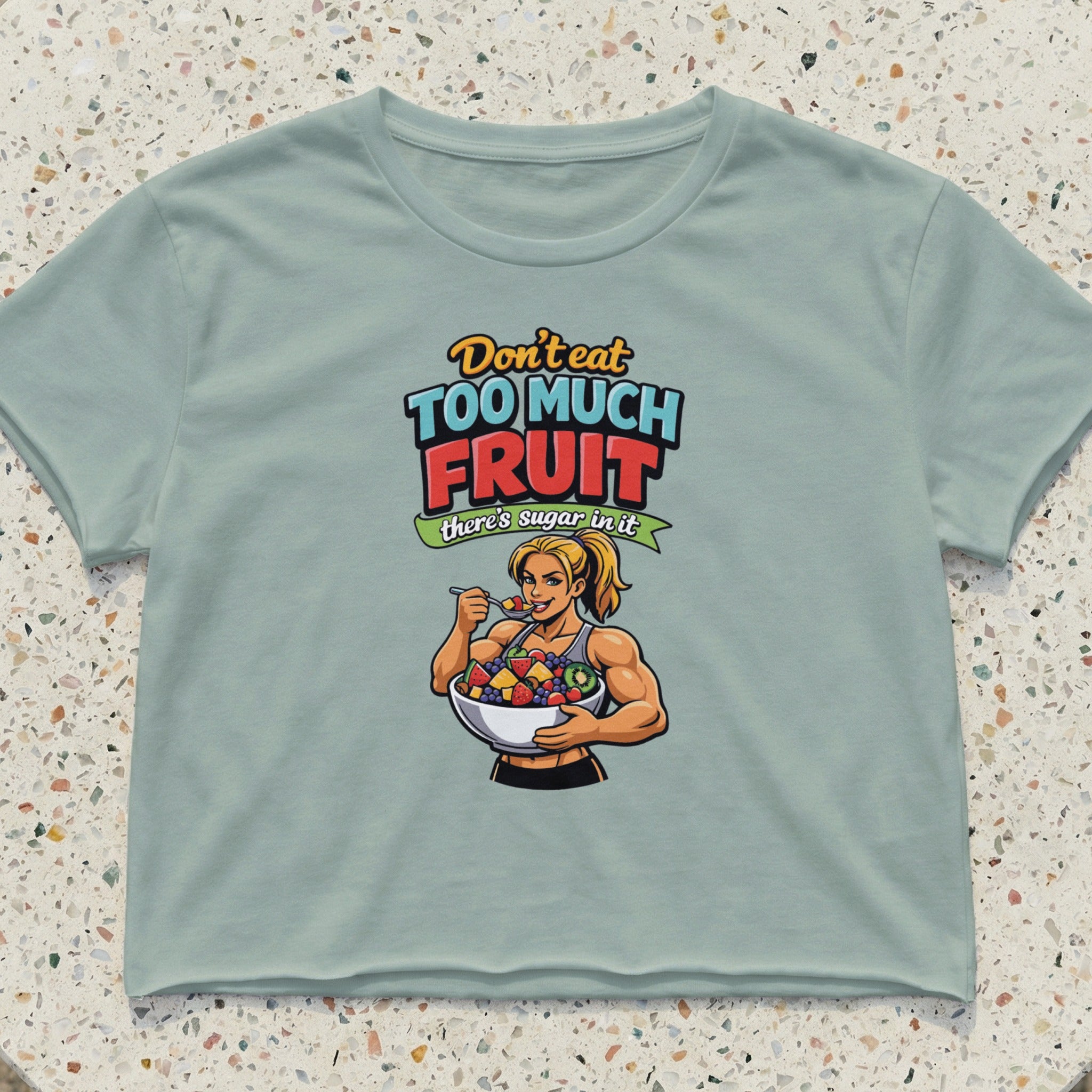 Crop top with cartoon of muscular woman eating fruit salad, text: "Don't eat too much sugar there's sugar in it"