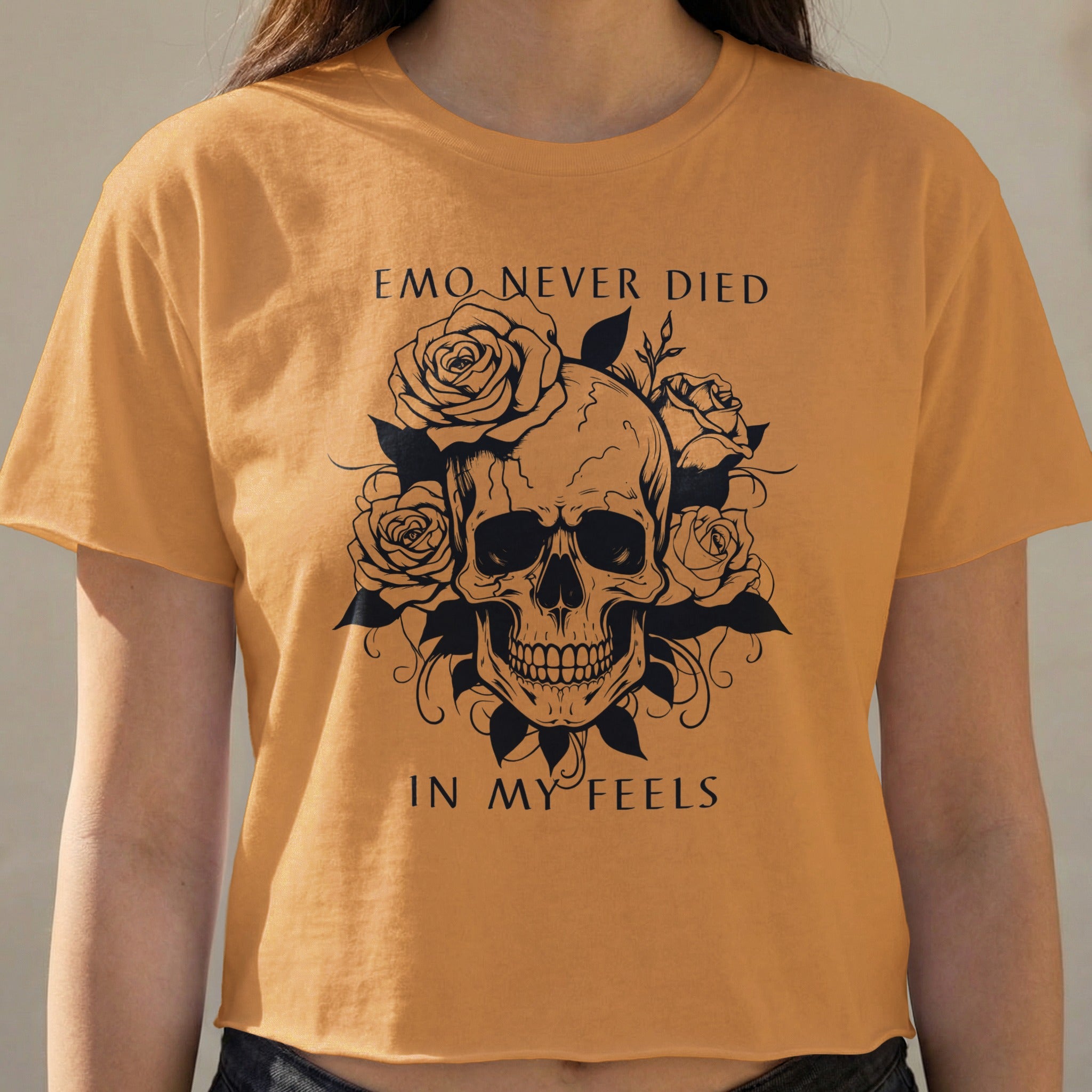 Orange t-shirt with black skull and roses graphic, text reads "EMO NEVER DIED IN MY FEELS".