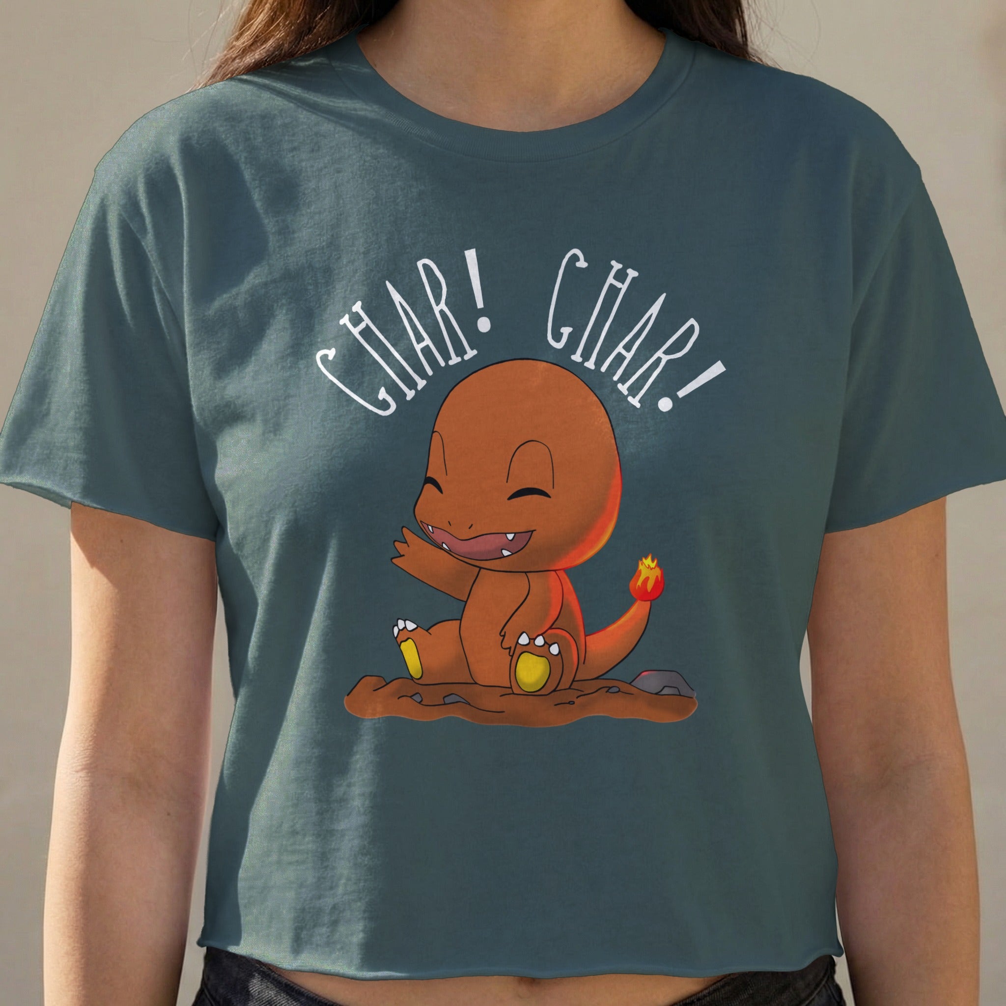 Charmander graphic on a dark teal cropped t-shirt.