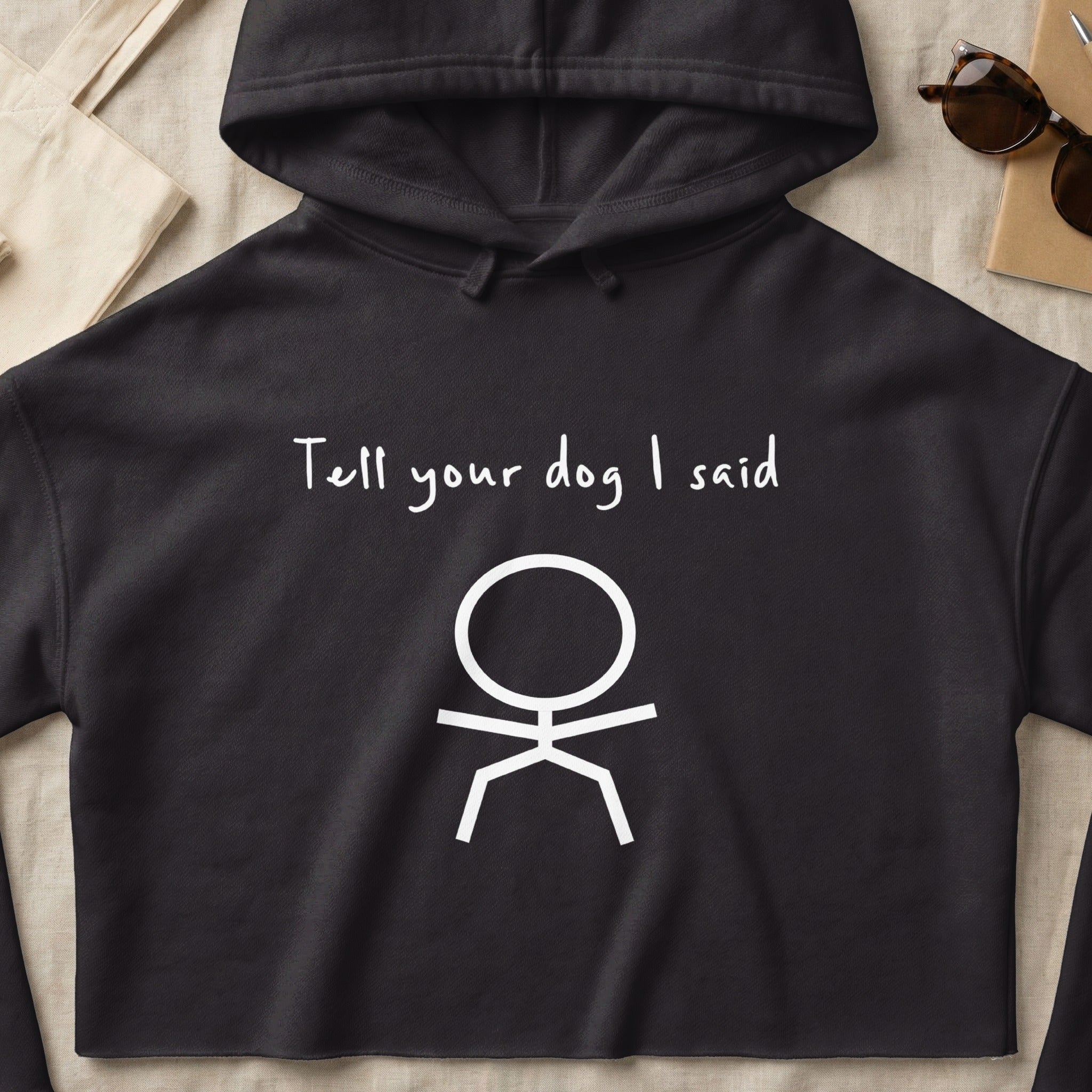 Black hoodie with white text "Tell your dog I said" and a stick figure.