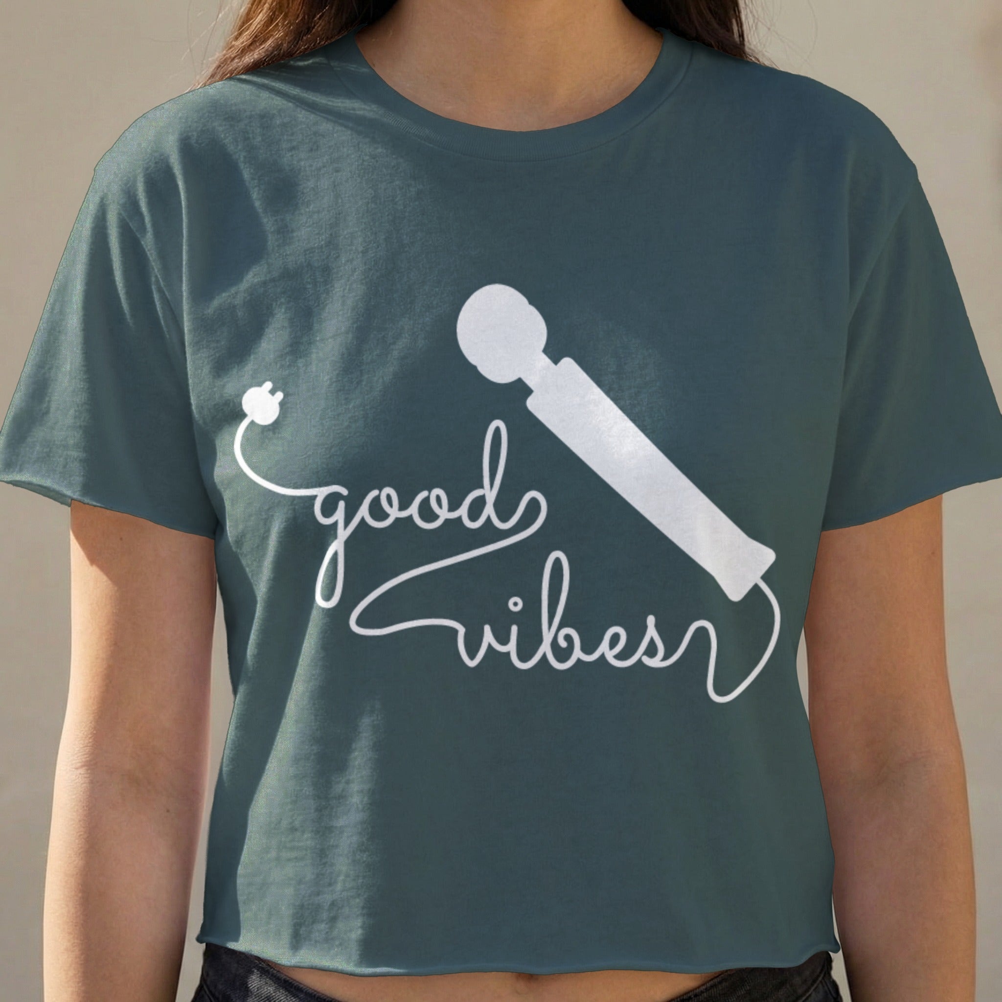 White wand vibrator graphic with "good vibes" text on a dark teal cropped t-shirt.