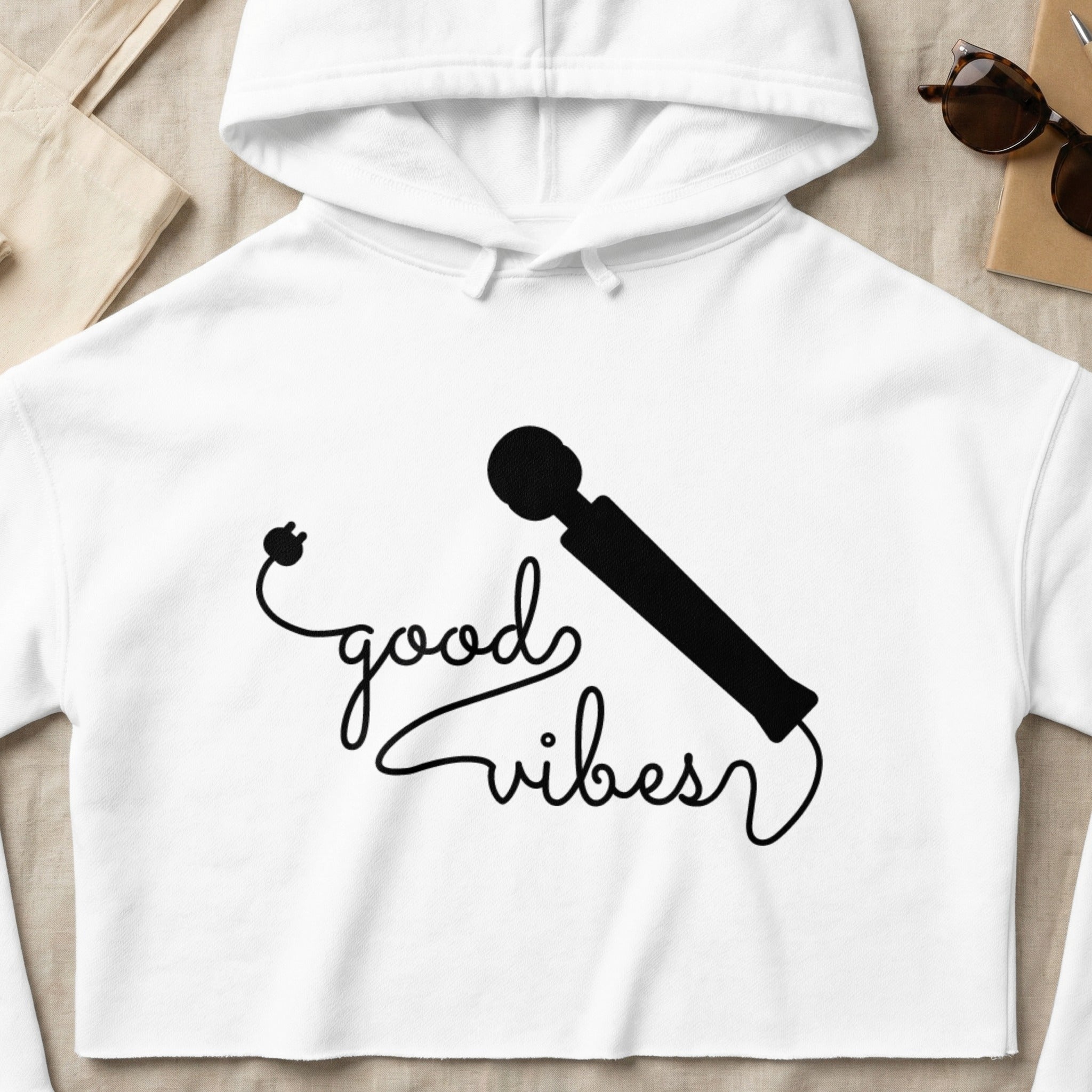 White cropped hoodie with "good vibes" text and a wand illustration.