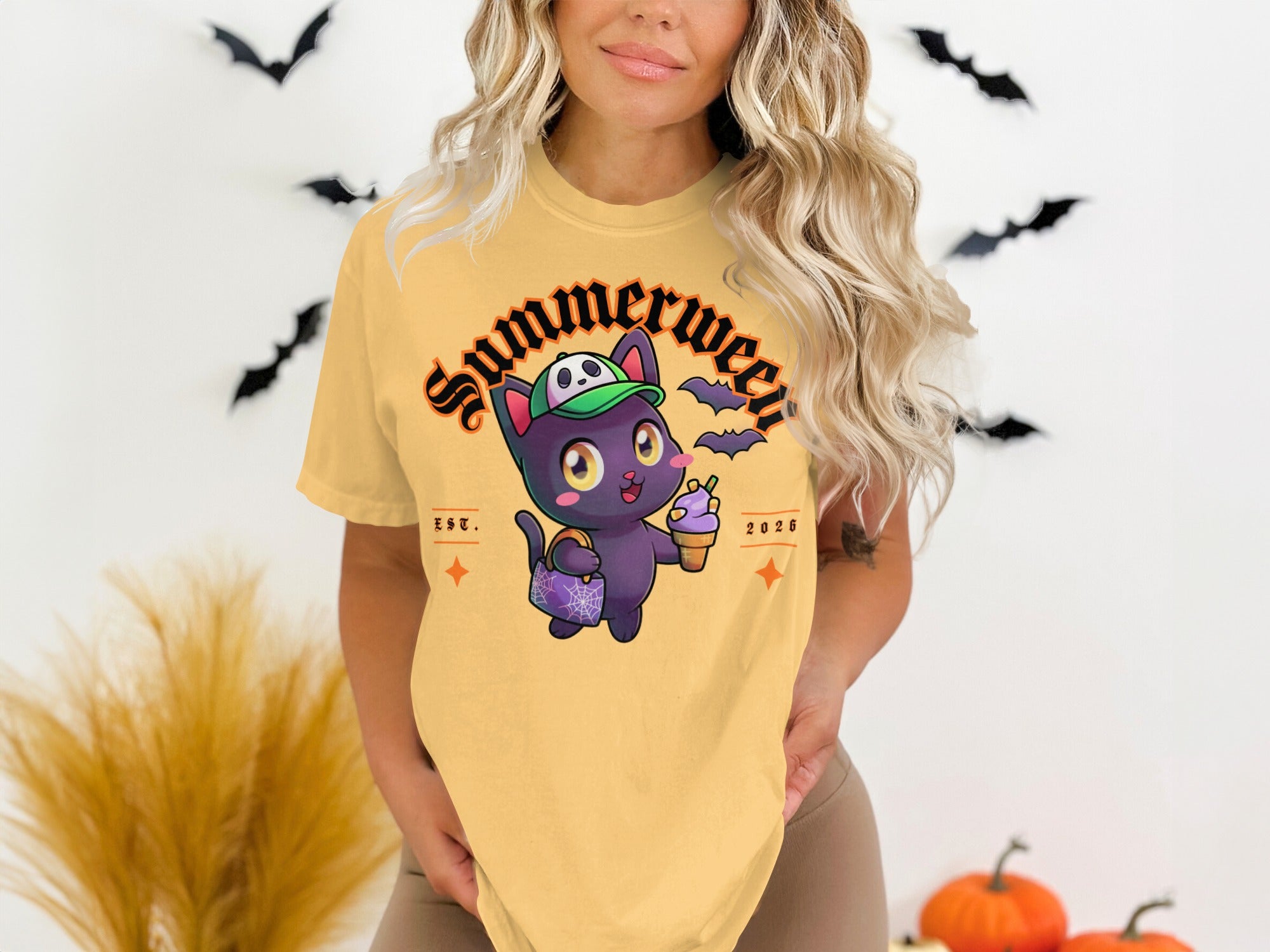 Yellow t-shirt with graphic of a black cat holding ice cream and candy bag, "Summerween" text.