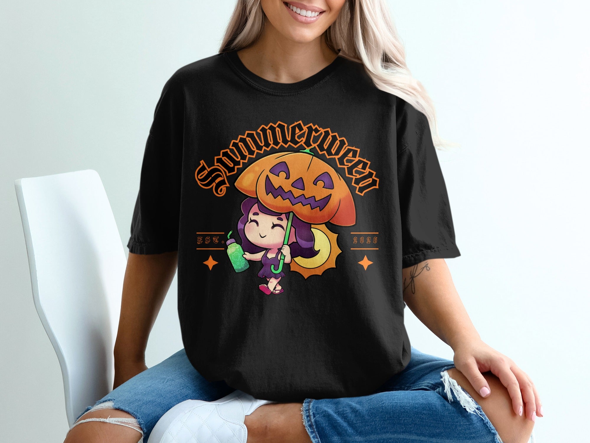 Black t-shirt with "Summerween" graphic of girl under pumpkin umbrella, holding a drink.
