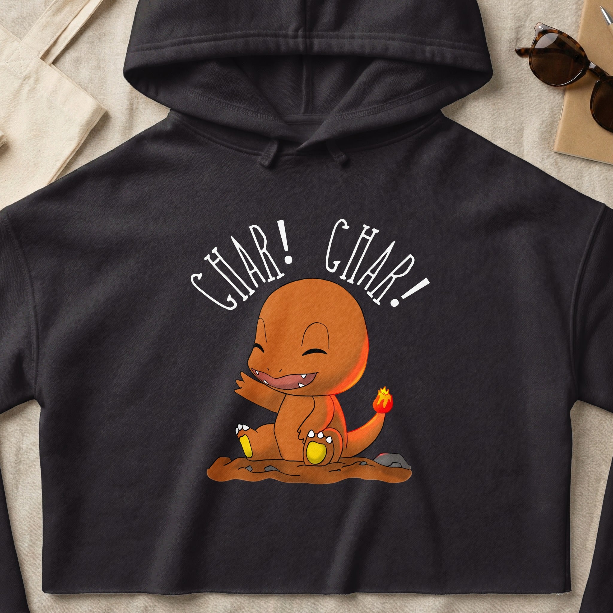 Charmander sitting and saying "Char! Char!" on a dark hoodie.